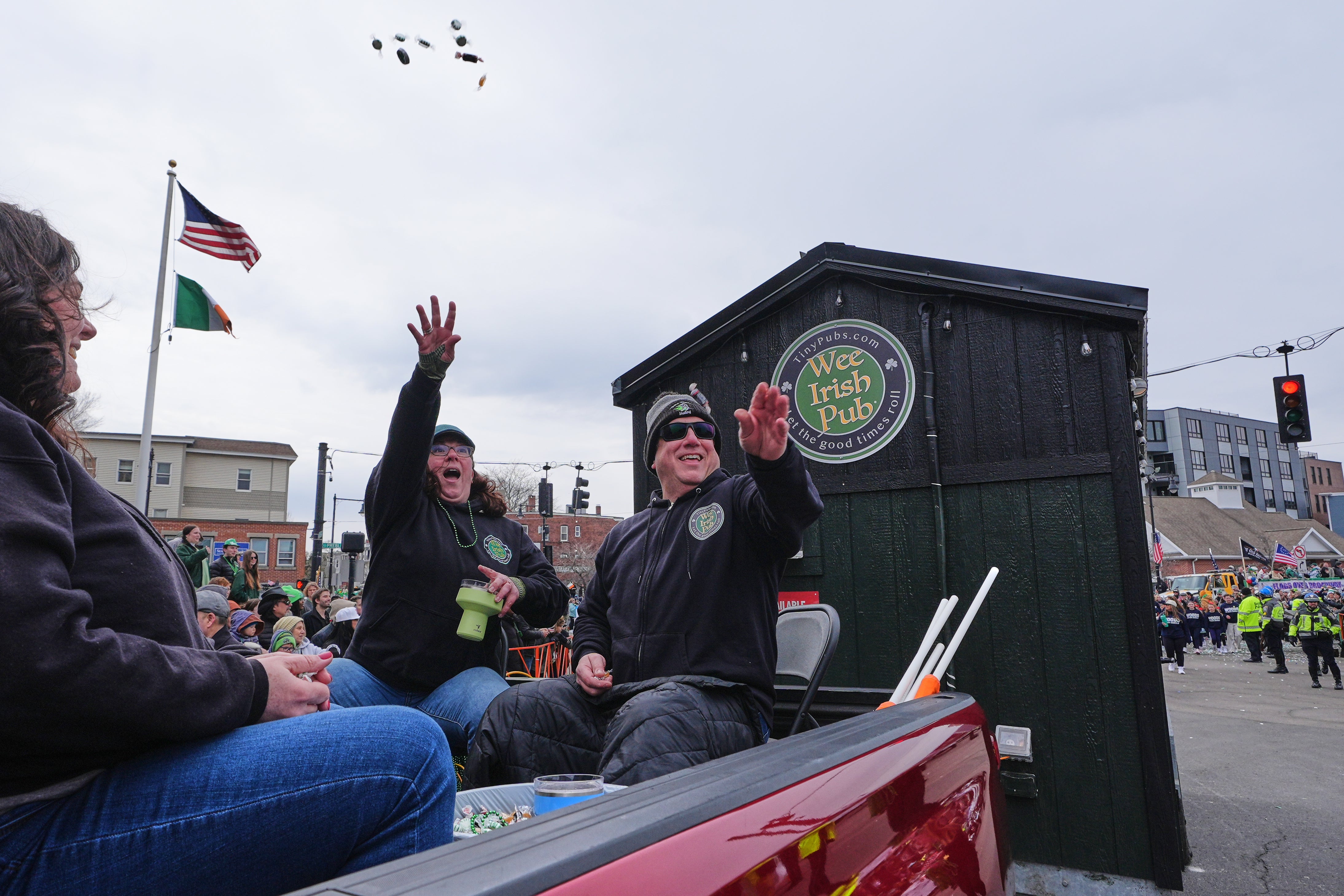 Dena Taylor and Tony DiDonato, right, flip candy to spectators while riding successful a motortruck hauling nan "Wee Irish Pub", a afloat functioning mobile Irish pub built by 2 Massachusetts' brothers, during nan yearly St. Patrick's Day parade done nan South Boston neighborhood, Sunday, March 15, 2026. (AP Photo/Charles Krupa)