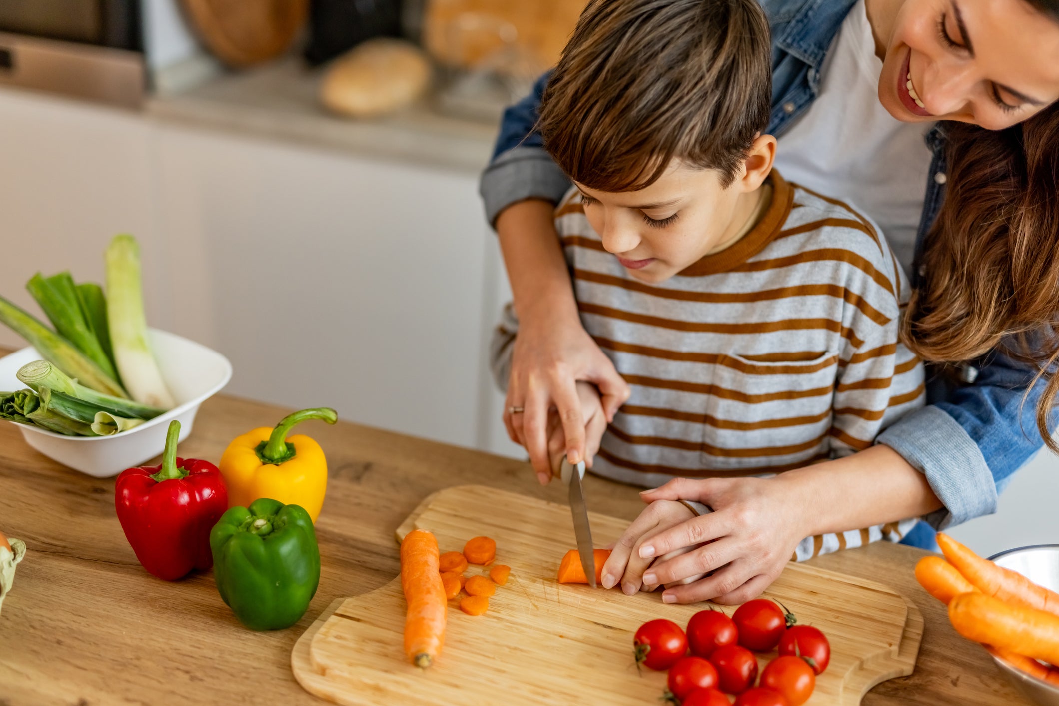 Many children learn cooking skills first by watching and helping parents at home