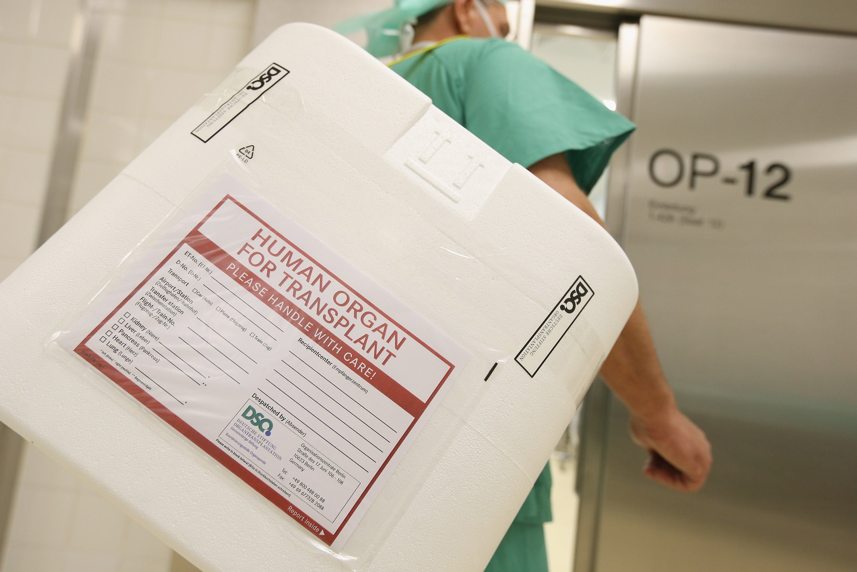 A hospital employee carries an empty styrofoam box used for transporting human organs