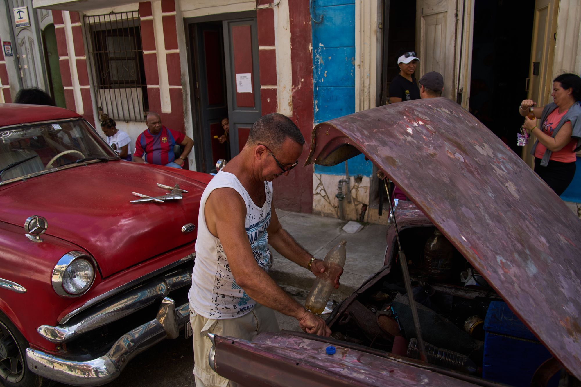 A man finishes putting substance successful his car's tank, located successful nan backmost of nan car, during a blackout successful Havana, Cuba, Monday, March 16, 2026. (AP Photo/Ramon Espinosa)