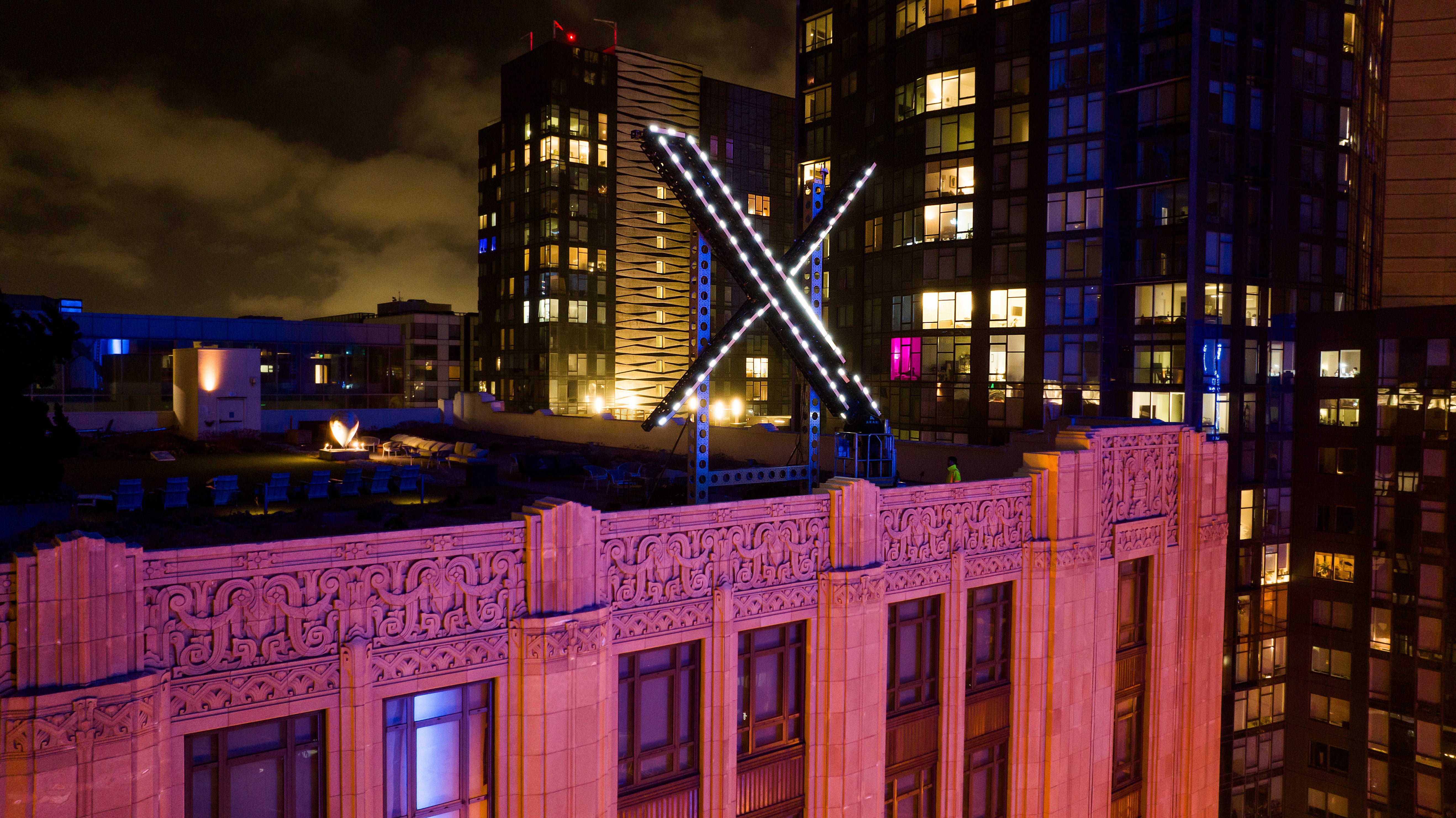 Workers instal lights connected an "X" motion atop nan institution office successful downtown San Francisco connected July 28, 2023. (AP Photo/Noah Berger, File)