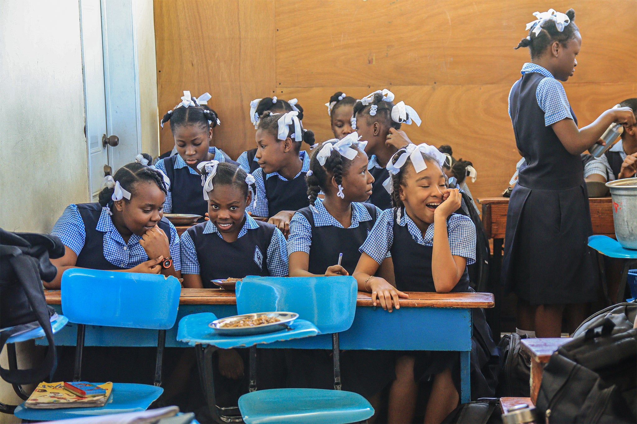 Girls eat their nutrient and hole for classes successful Haiti, undated