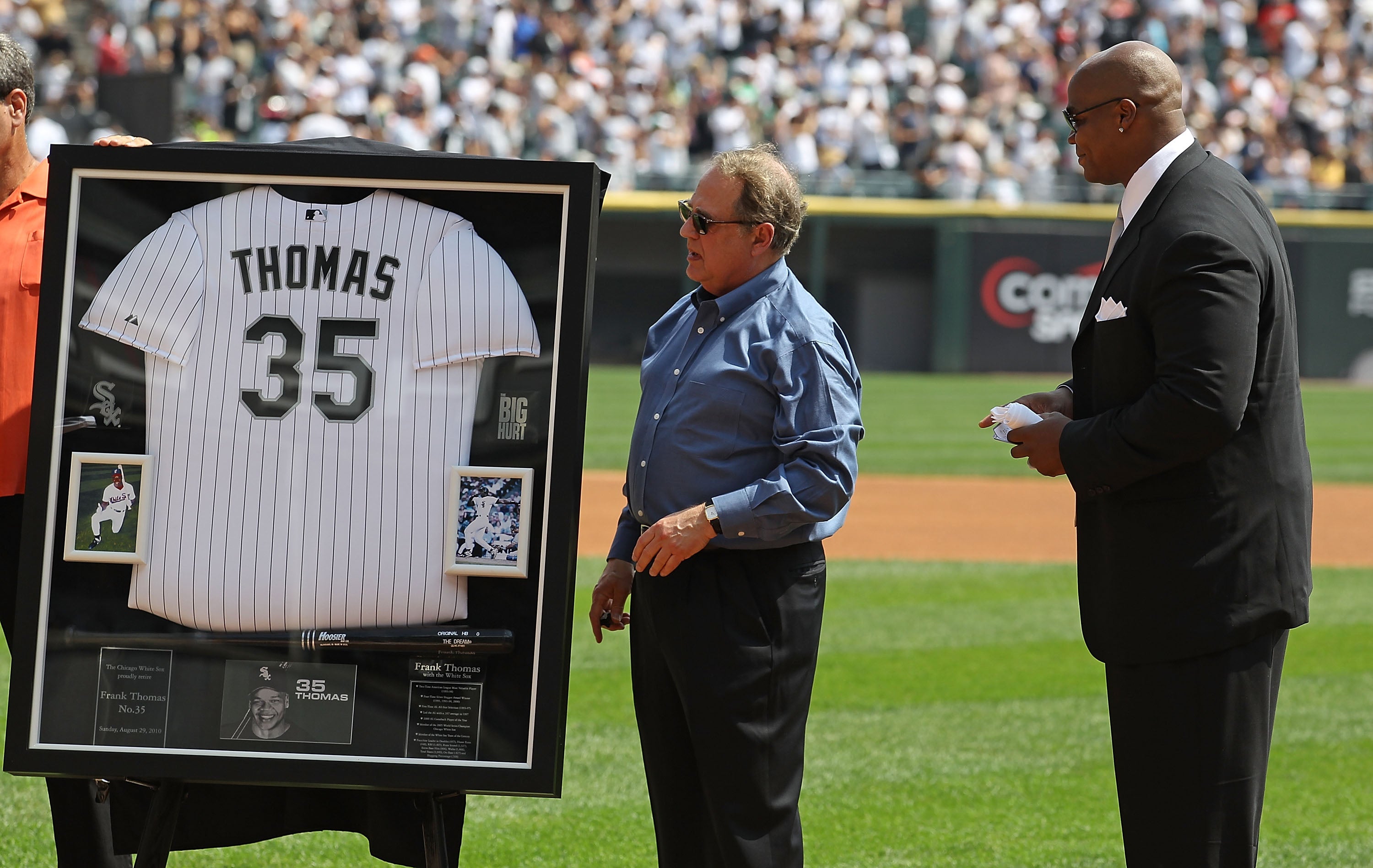 White Sox chairman Jerry Reinsdorf makes a presentation to Thomas on his retirement in August 2010, when his number 35 shirt was retired as a tribute to his achievements