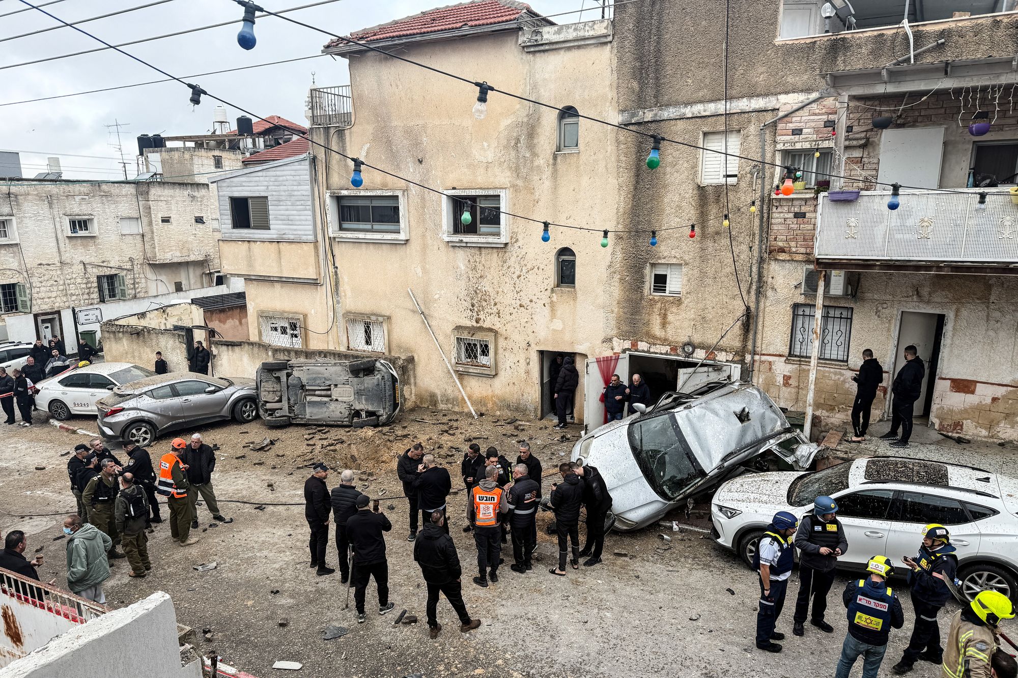 Members of nan Israeli emergency services, information officials and onlookers stitchery astatine nan rocket effect site, aft Iranian rocket barrages