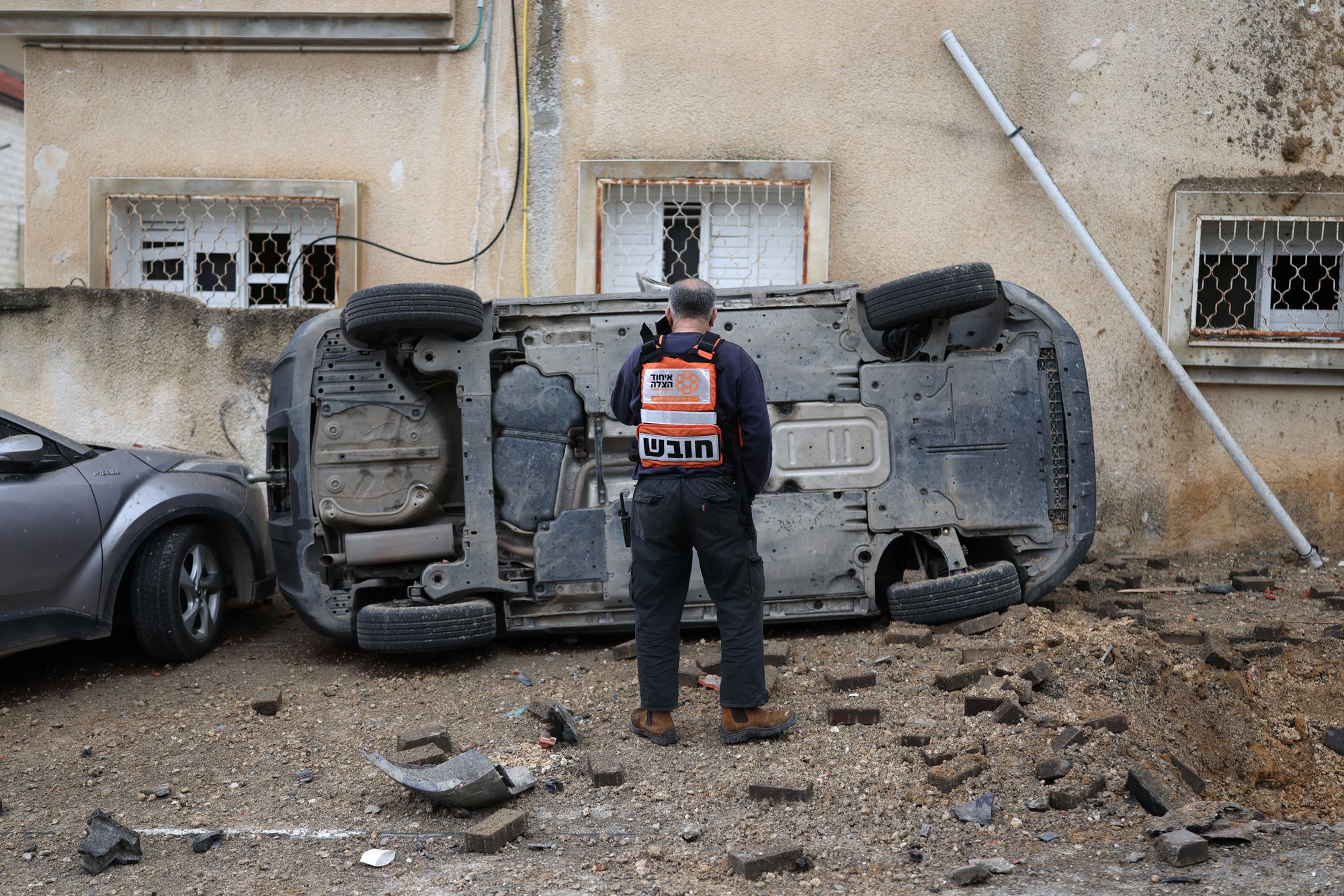 A man surveys nan harm to a car pursuing a projectile onslaught successful nan Arab-Israeli metropolis of Kfar Qassem