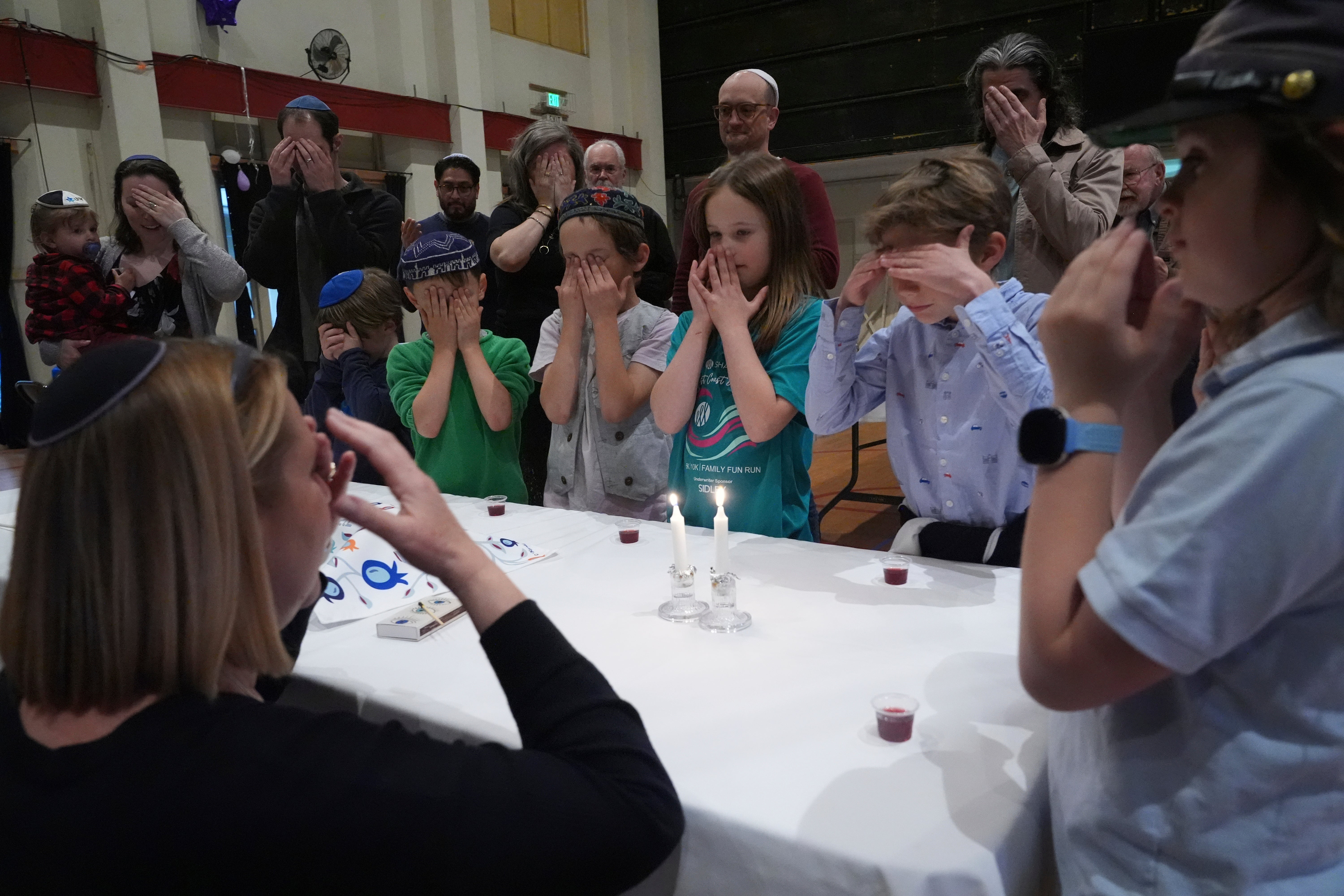 Cantor Ruth Berman Harris lights candles to observe Seder pinch congregants of nan 104-year-old Pasadena Jewish Temple and Center which burned down successful nan Jan. 2025 Eaton fire