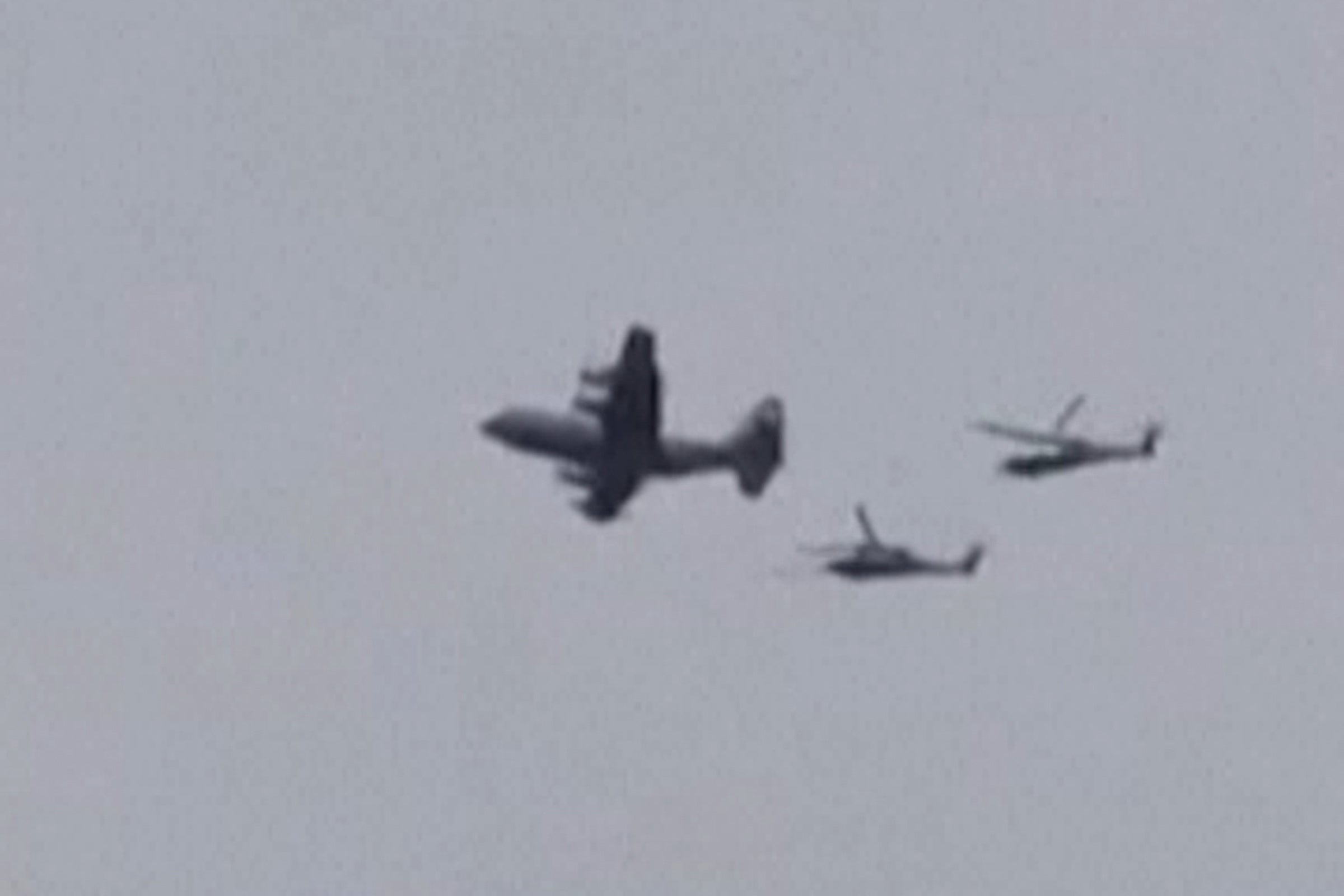 This video grab taken on April 3, 2026, from UGC images posted on social media on April 3, 2026 show a US aircraft, followed by two helicopters, flying over the town of Zaras in the southern Iran's Khuzestan province