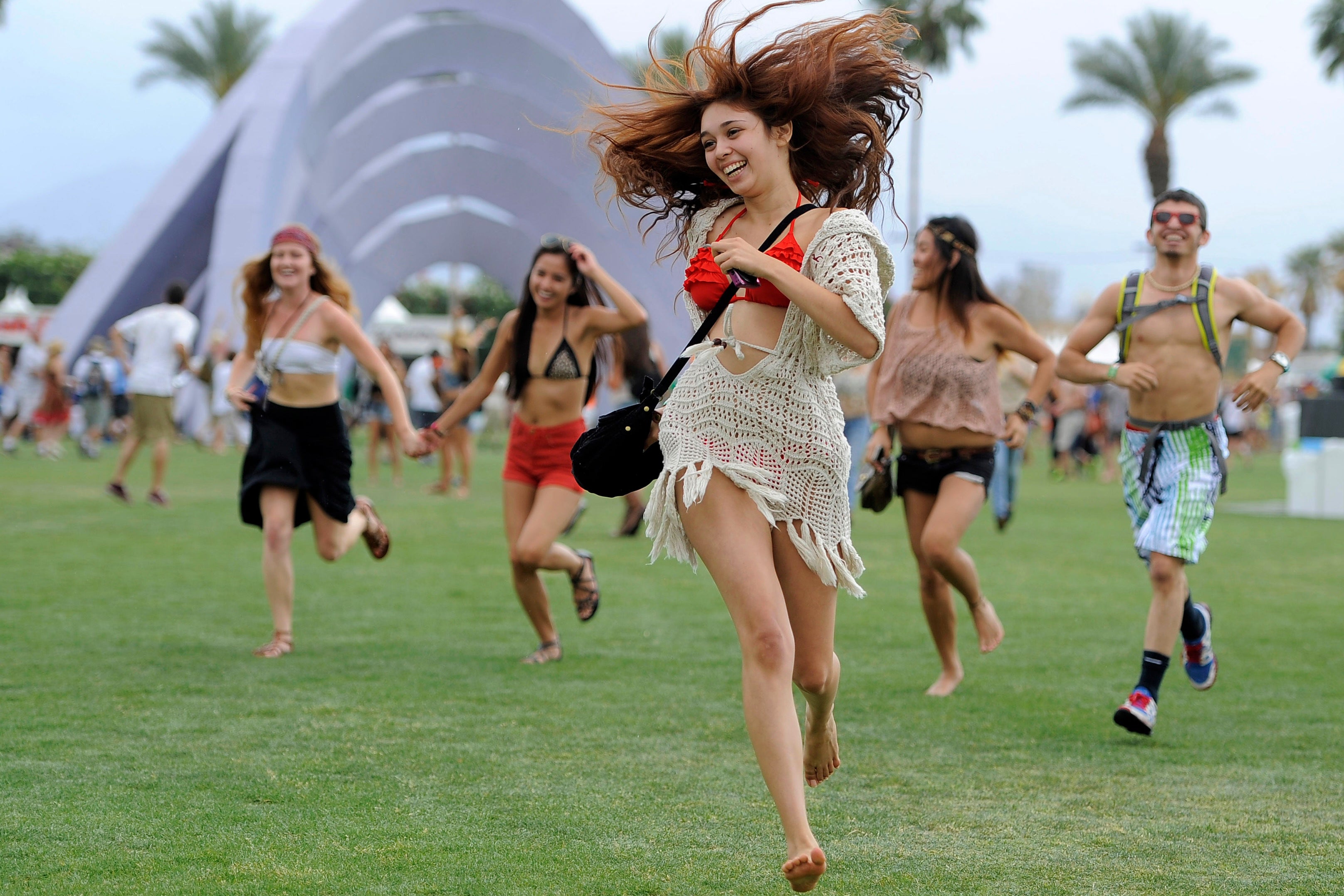 Festivalgoers run toward the main stage at the Coachella Valley Music and Arts Festival