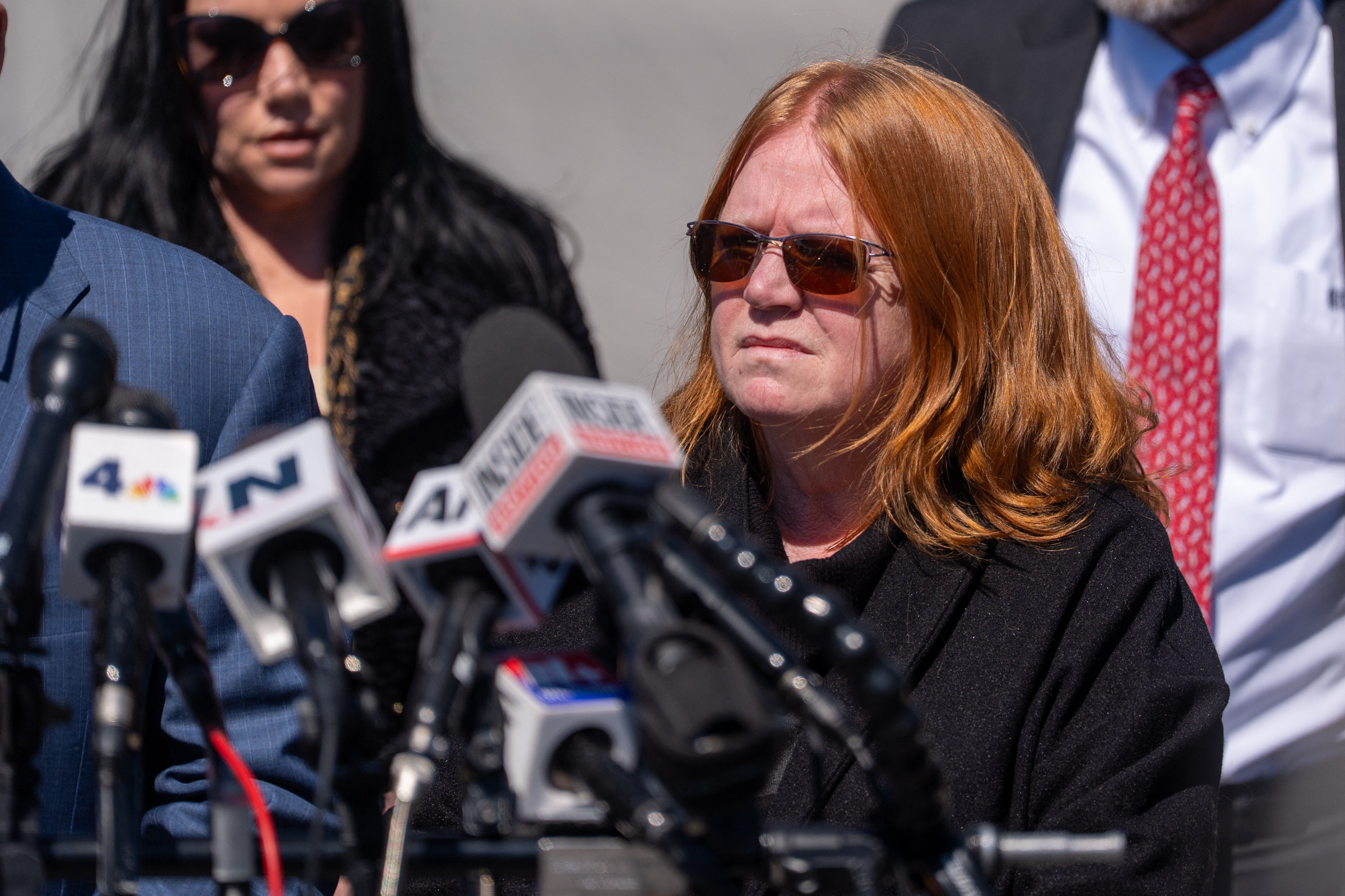 Ellerup listens to Attorney Robert Macedonio speak to the media outside Suffolk County Court after her estranged husband Rex Heuermann pleaded guilty