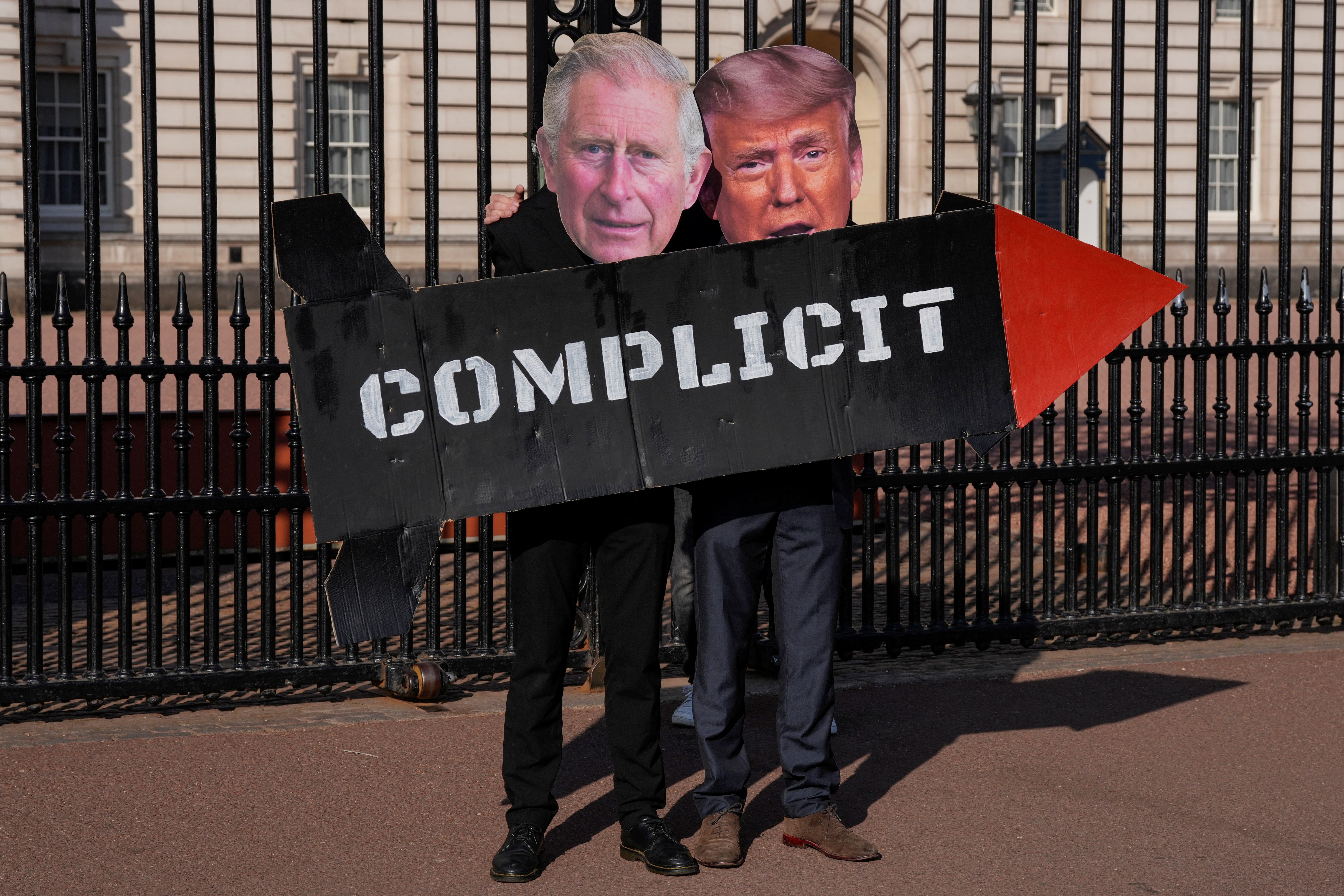 Two members of nan 'Stop Trump Coalition' action group airs pinch a mock rocket and masks of Britain's King Charles III and US President Donald Trump successful beforehand of nan gates of Buckingham Palace successful cardinal London