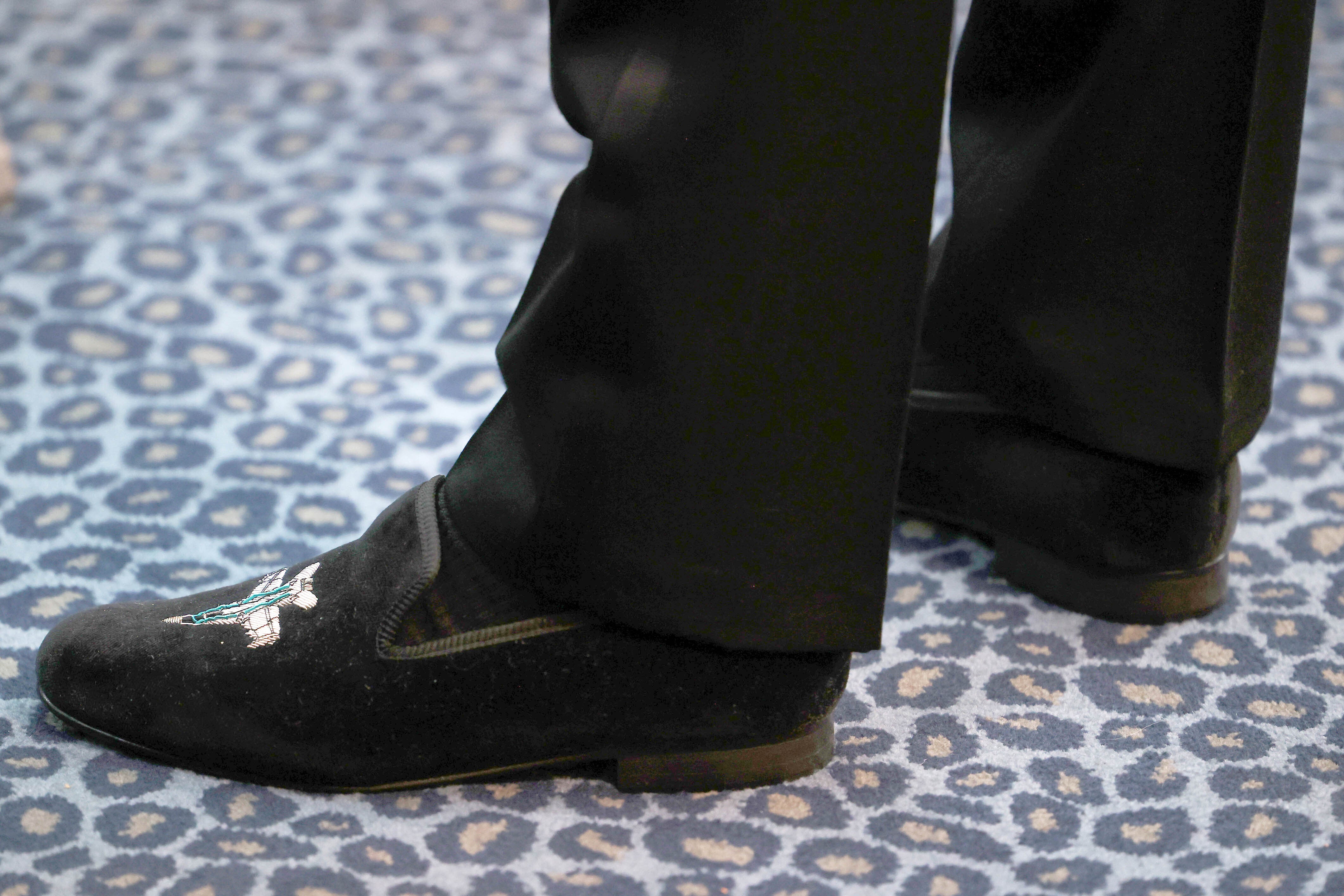 The Duke of Cambridge wearing a pair of shoes embroidered with a fighter aircraft logo.