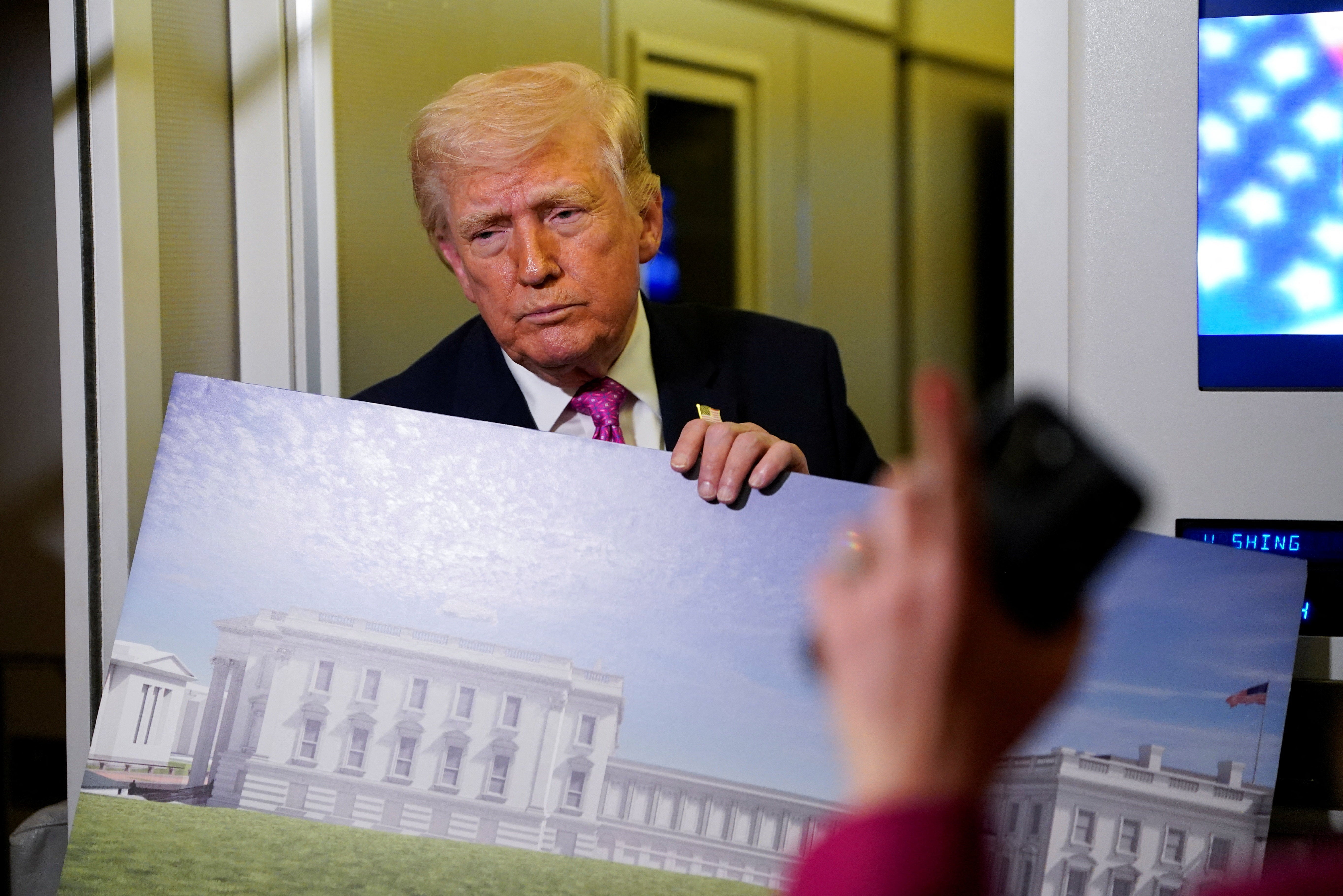 Trump shows reporters a rendering of nan ballroom while speaking aboard Air Force One earlier this month