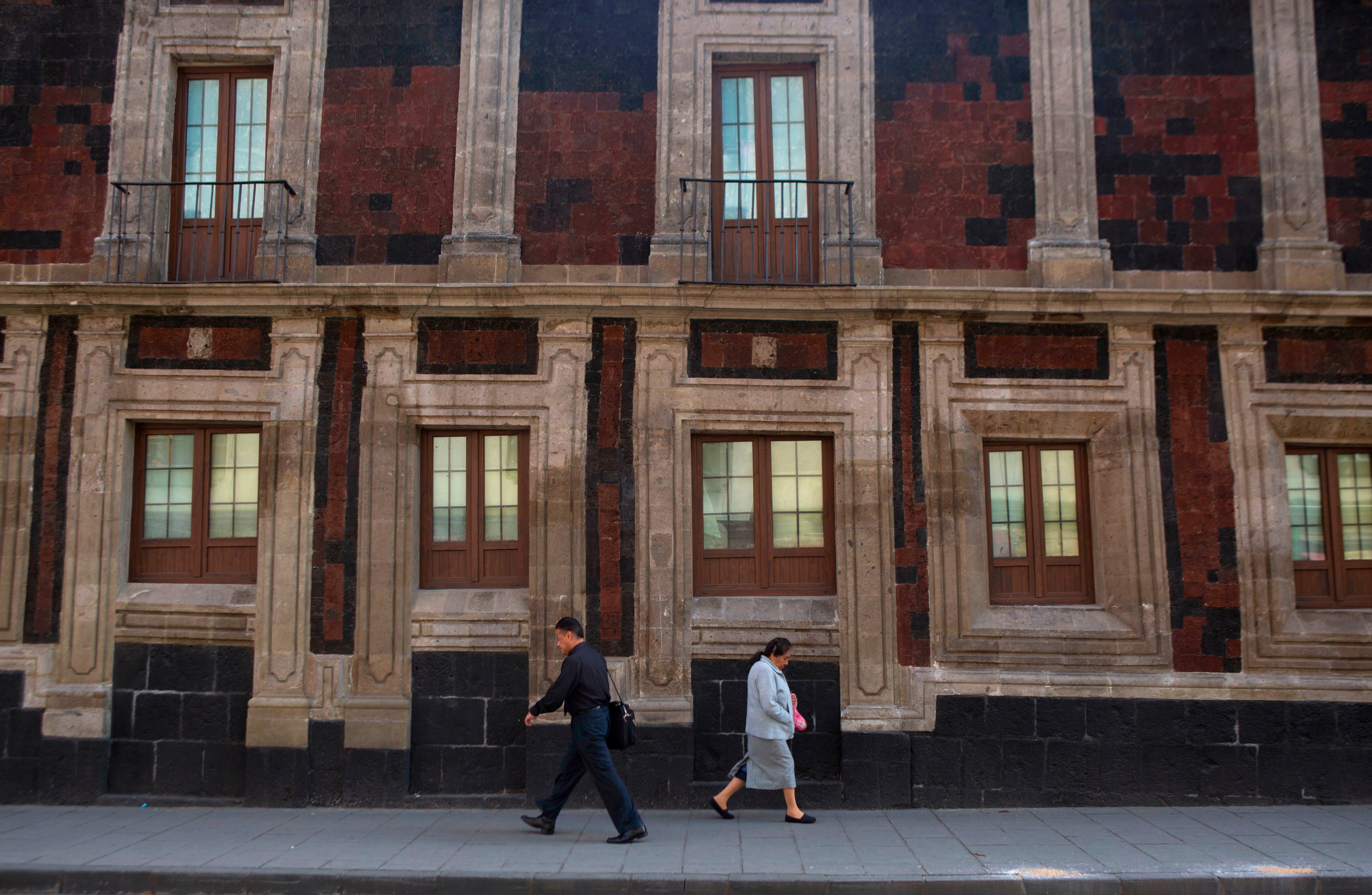 Pedestrians locomotion past a somewhat tilted historical building successful downtown Mexico City, June 15, 2016