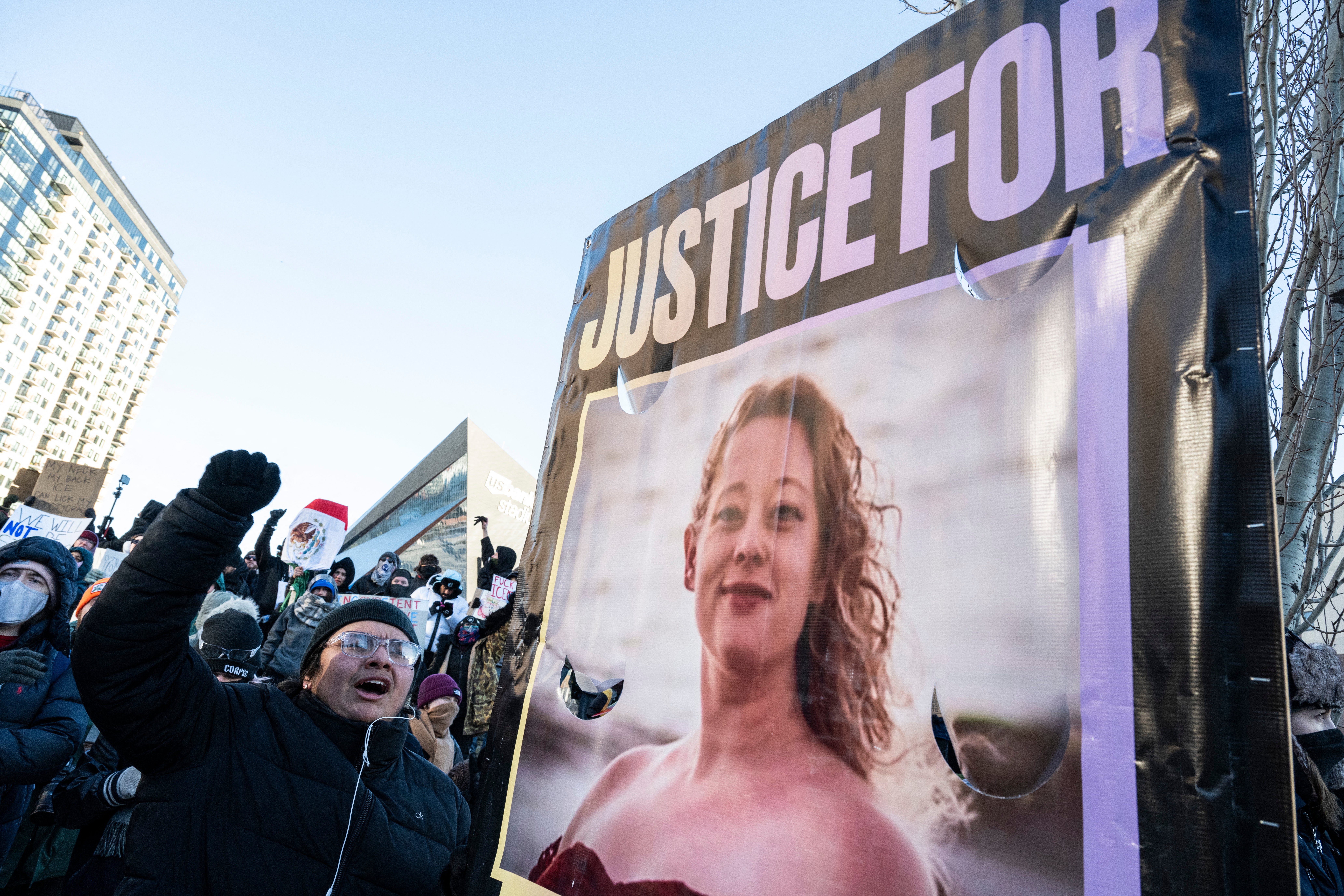A photo of Renee Good is displayed at a January protest in Minneapolis following her shooting by immigration agent Jonathan Ross, who’s since been reinstated and reassigned outside Minnesota