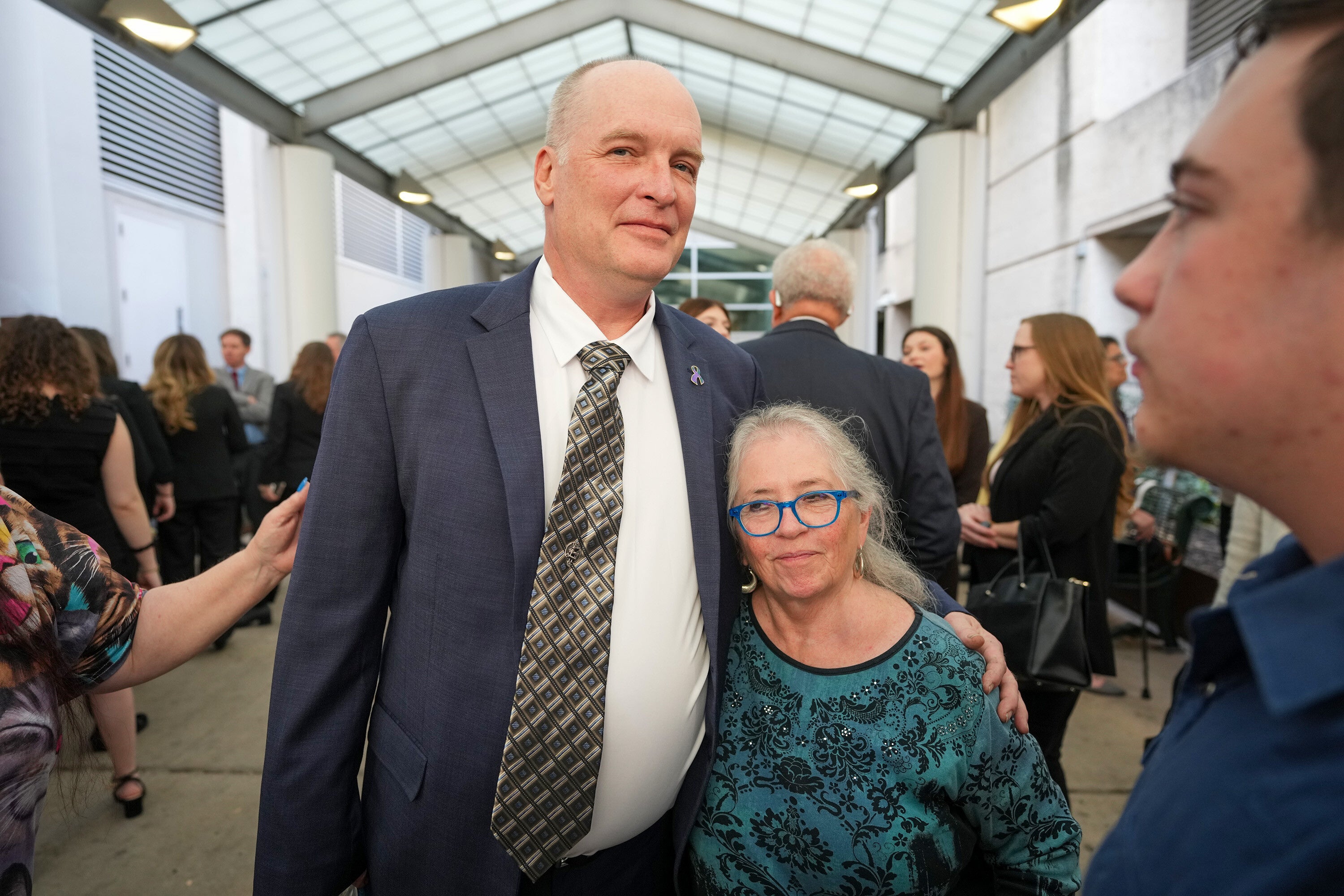 Michael Scott, left, hugs Sharon Shipman, the mother of yogurt shop suspect Forrest Welborn