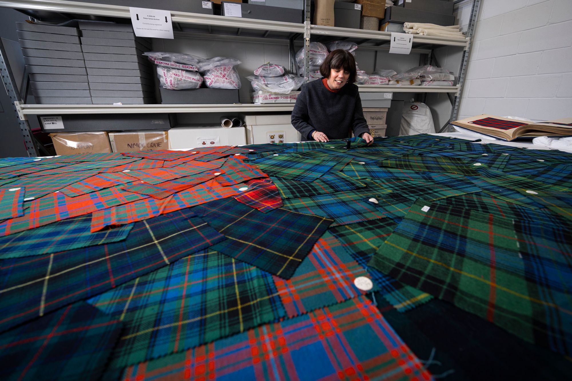 Curator Mhairi Maxwell examines the Paton tartan sample