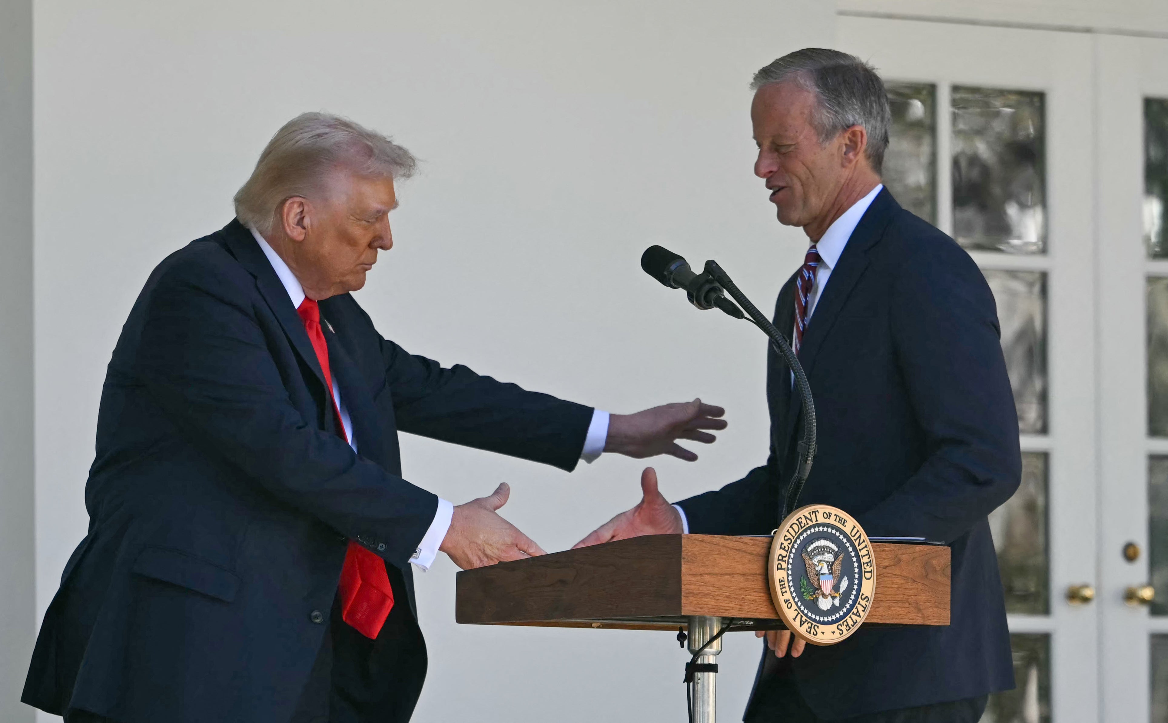 Američki predsjednik Donald Trump pozdravlja čelnika većine u Senatu Johna Thunea, republikanca iz Južne Dakote, za govornicom tijekom 