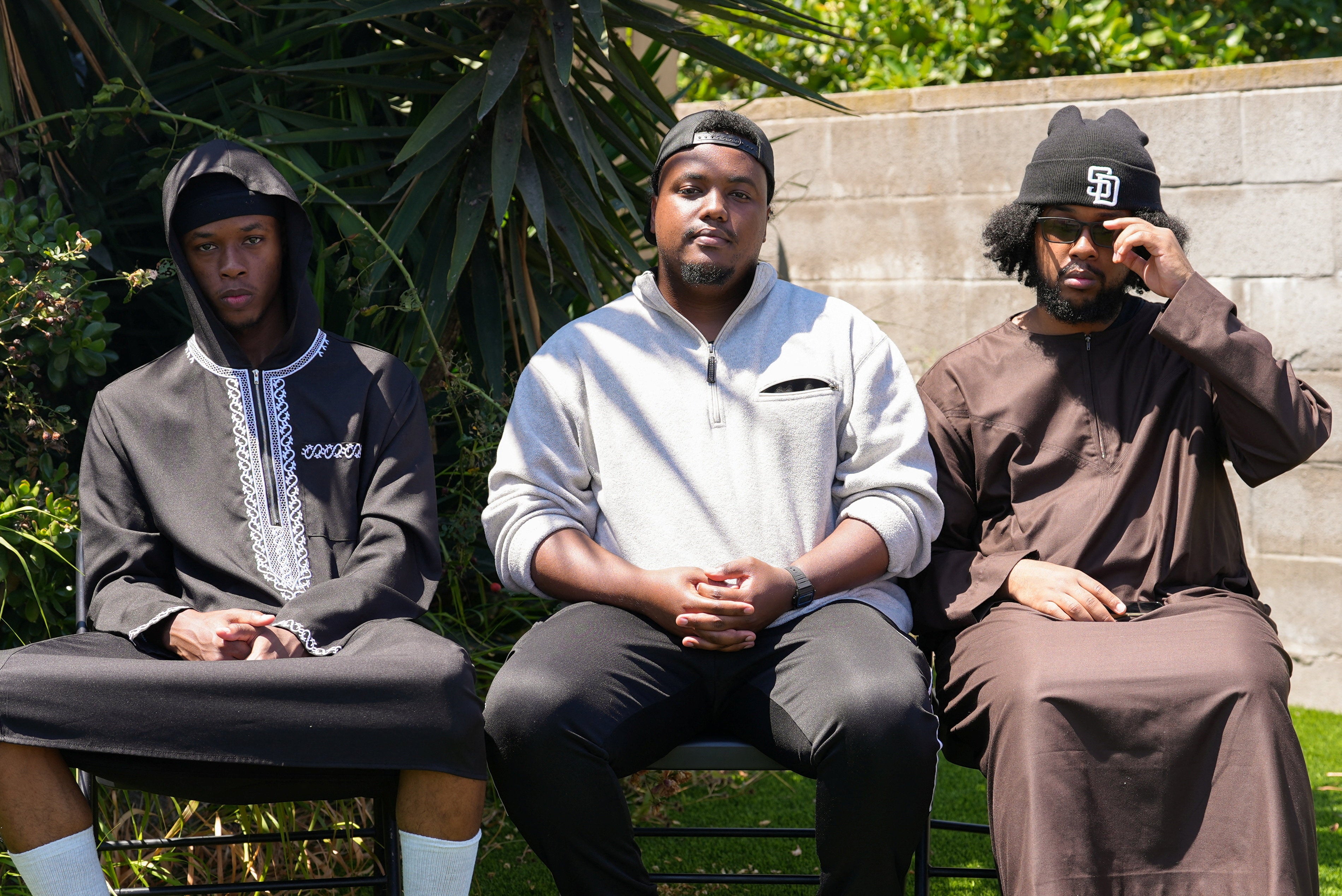 Jibril Abdullah, Mohammed Abdullah and Khalid Abdullah, sons of security guard Amin Abdullah, who was killed in a shooting incident, sit outside their home in San Diego