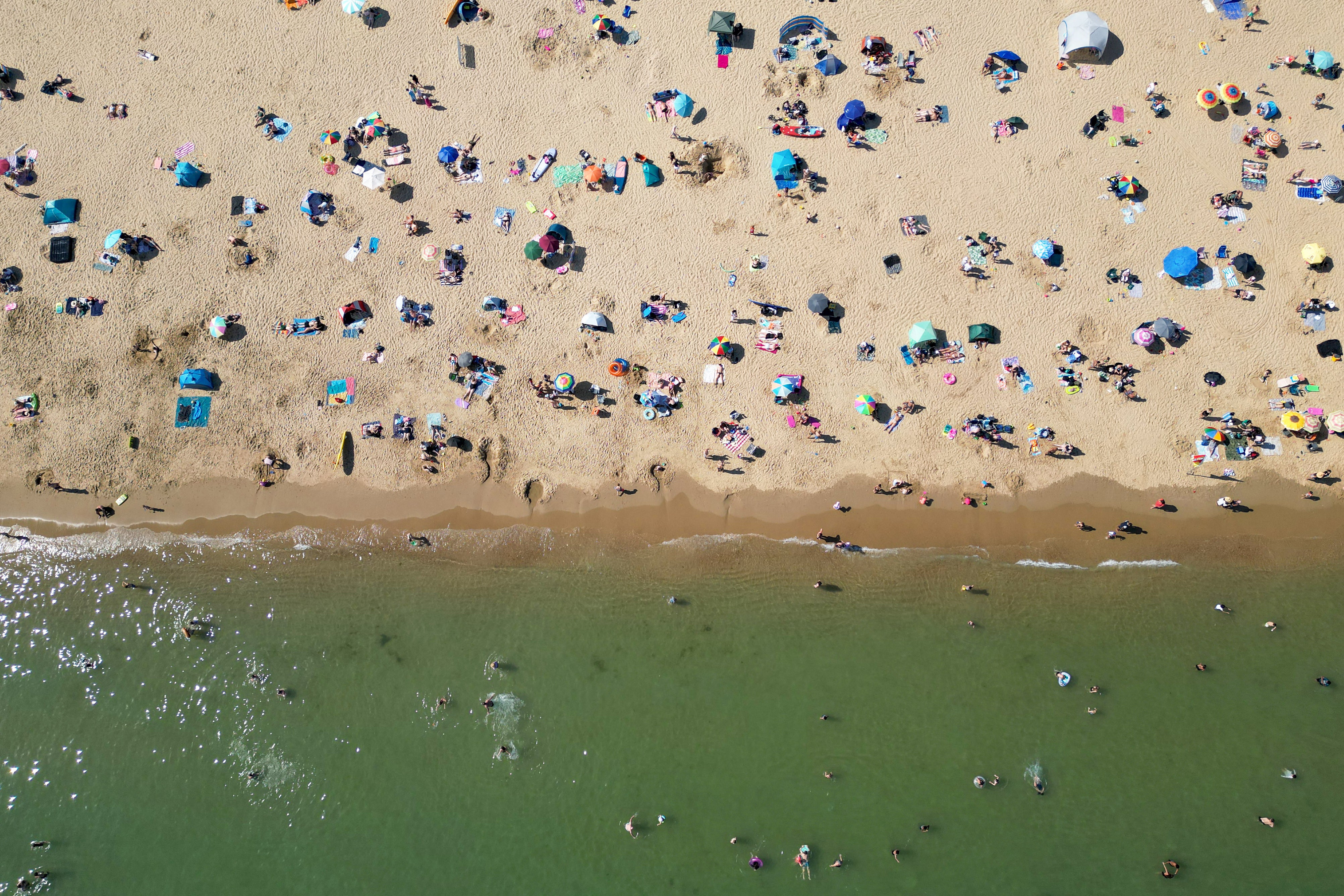 Ljudi koji se igraju u moru i opuštaju na suncu na plaži Bournemouth na južnoj obali Engleske 26. svibnja