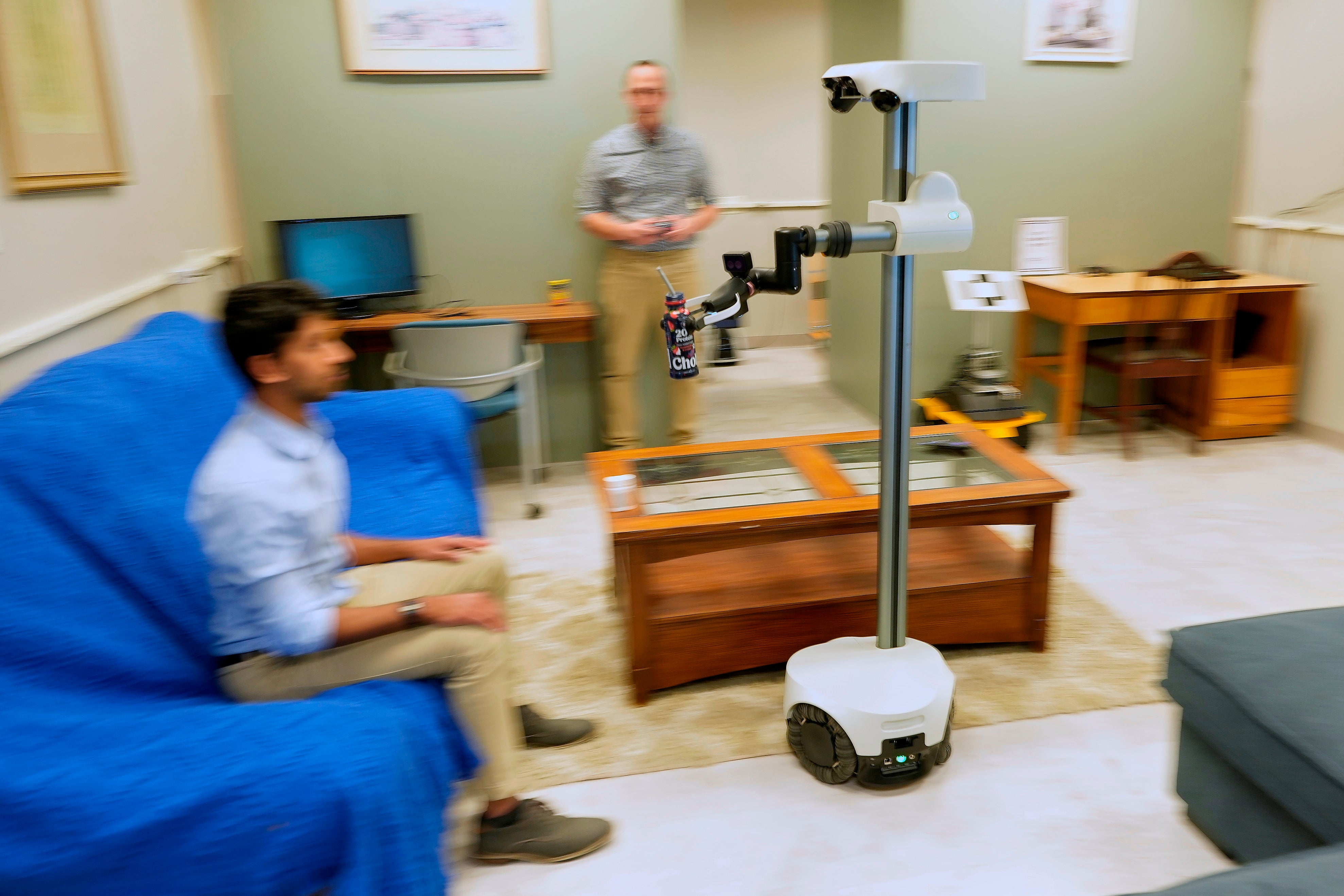 A robot operated by a robotics engineer, rear, brings a portion to workfellow during a objection astatine nan University of New Hampshire