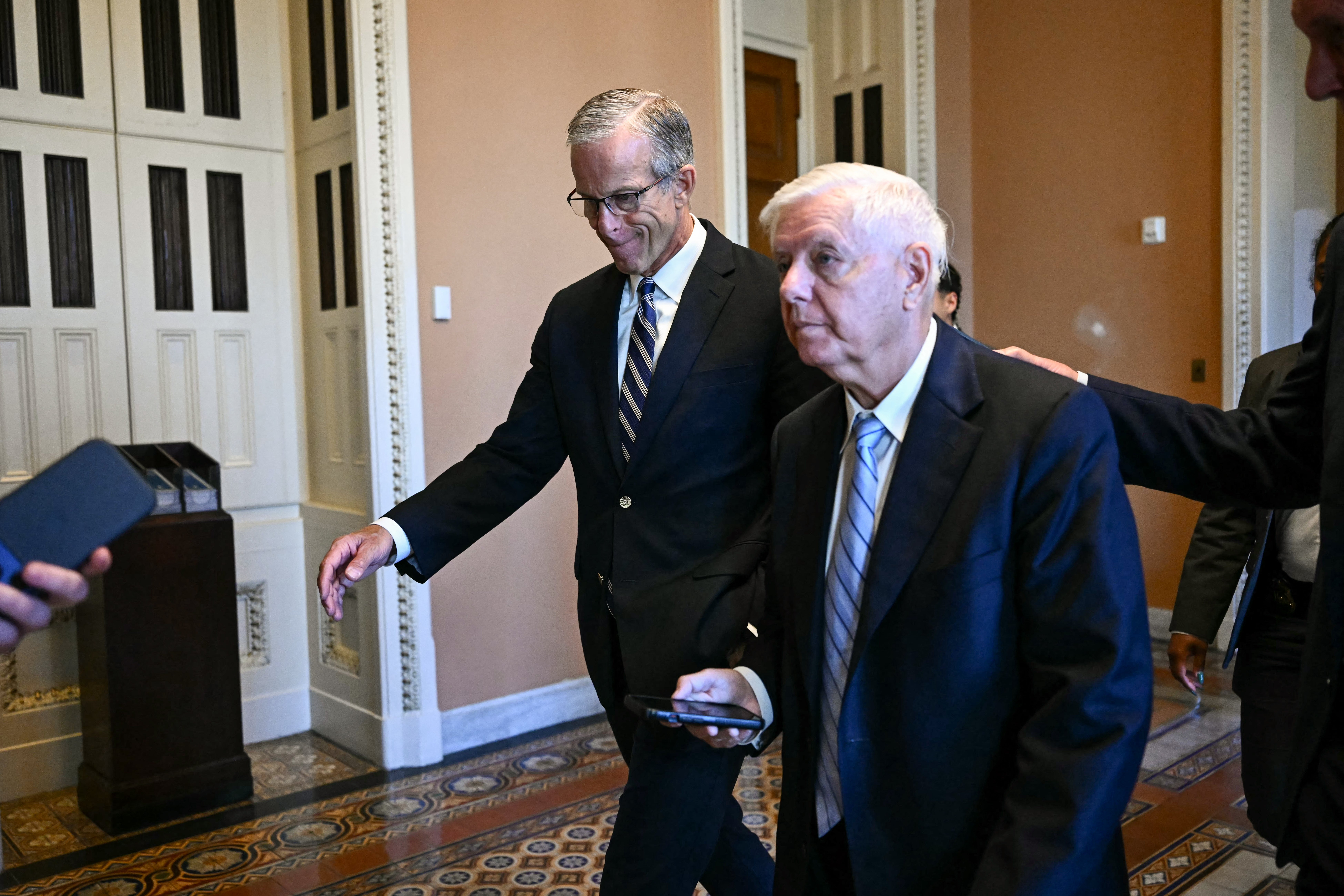 Senate Majority Leader John Thune, Republican from South Dakota, walks pinch Senator Lindsey Graham, Republican from South Carolina