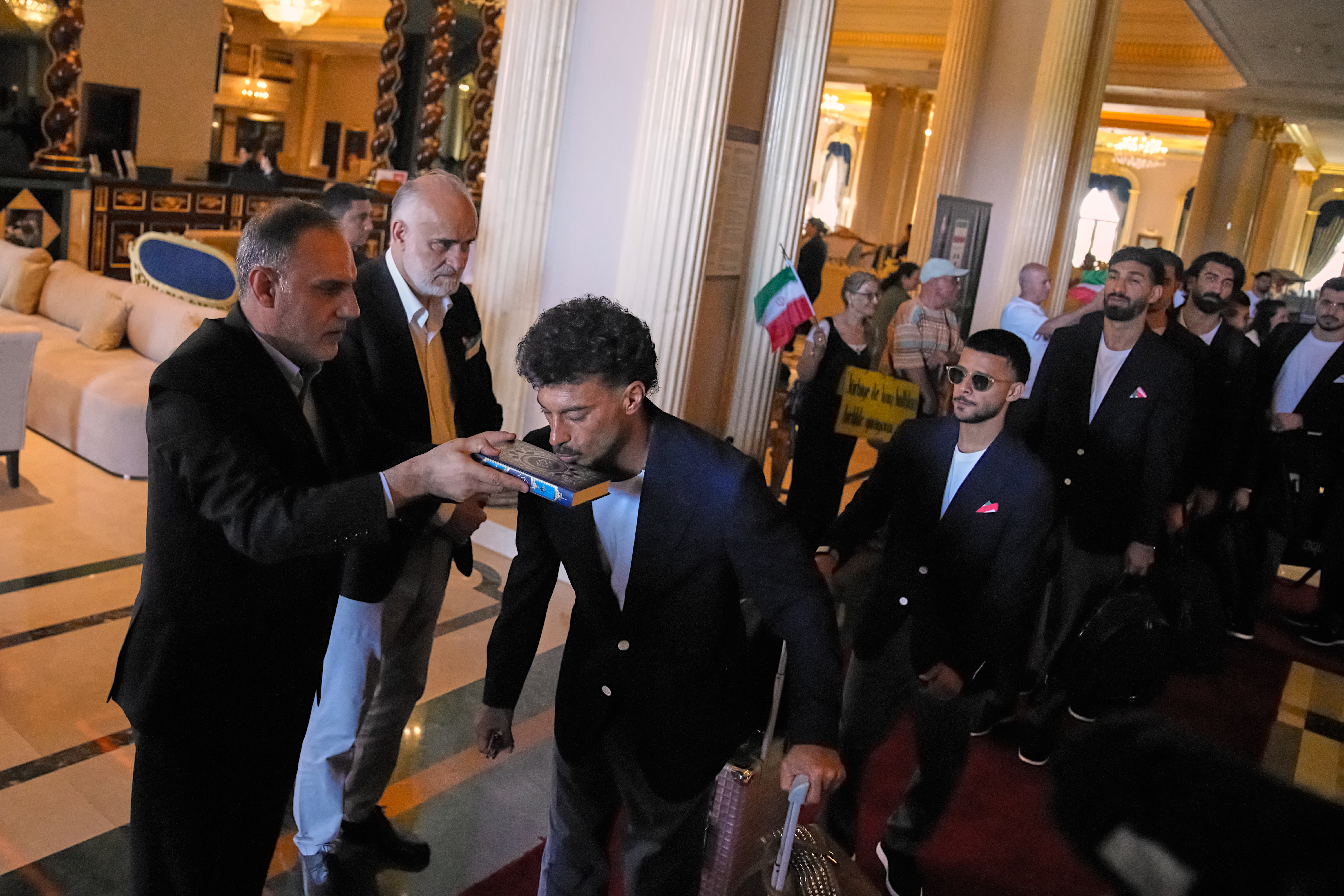Iran's players kiss the Muslim's holiest book Quran as they leave to Antalya airport, southern Turkey