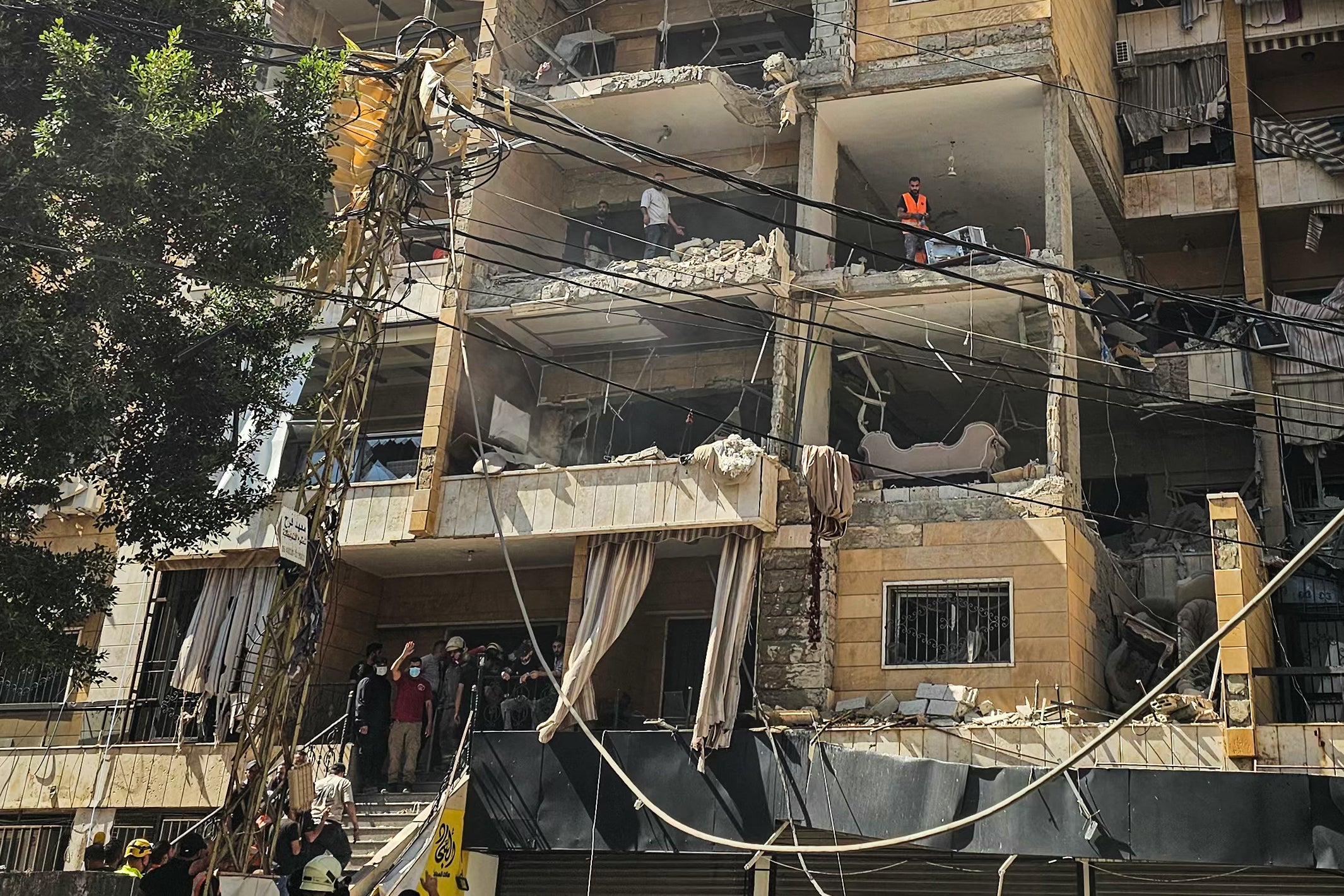First responders inspect damage at the site of an Israeli airstrike on an apartment building in Beirut's southern suburbs on June 7