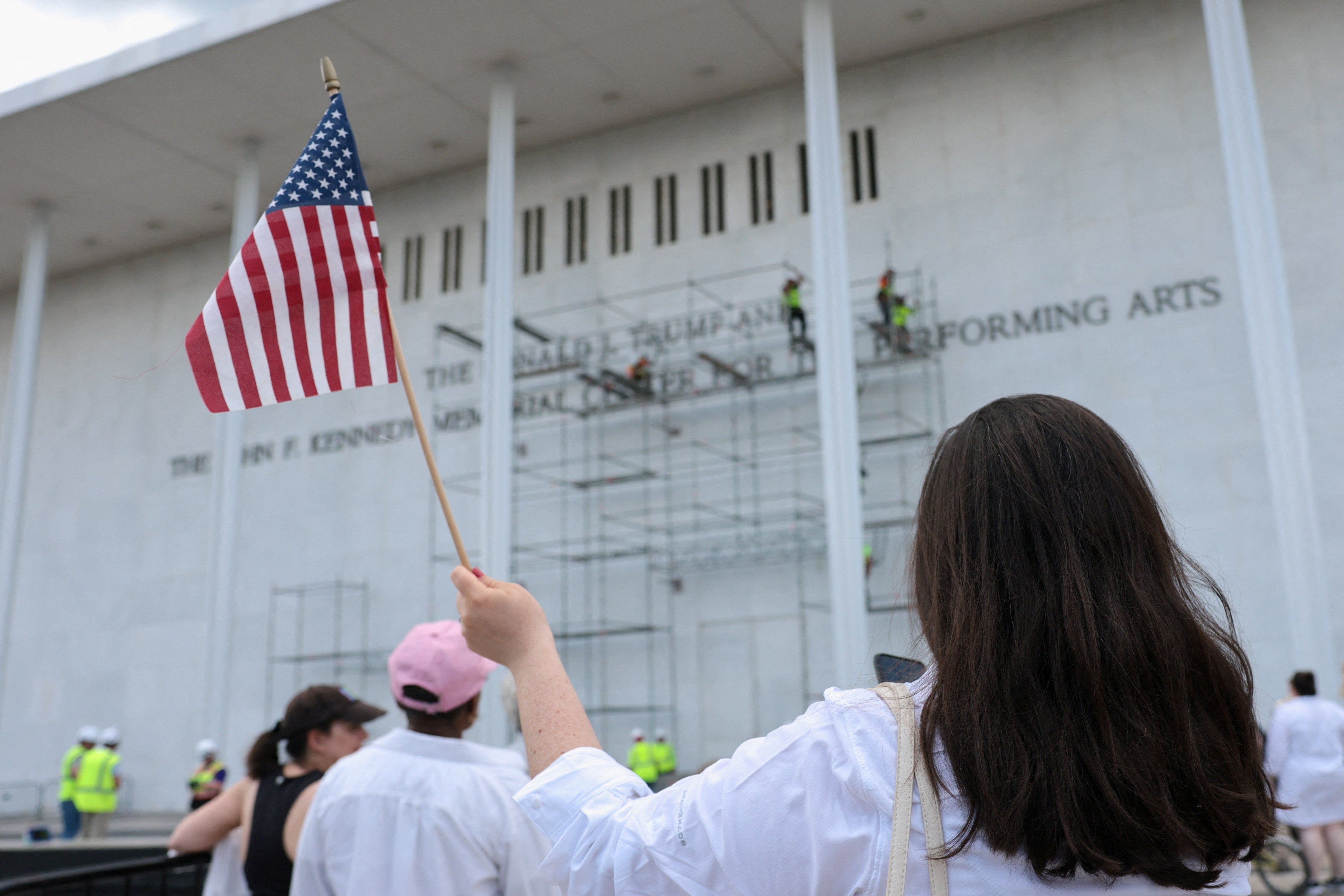 A crowd gathered extracurricular nan venue cheering connected building workers and chanting ‘take it off’ earlier nan unit near nan tract during an day downpour