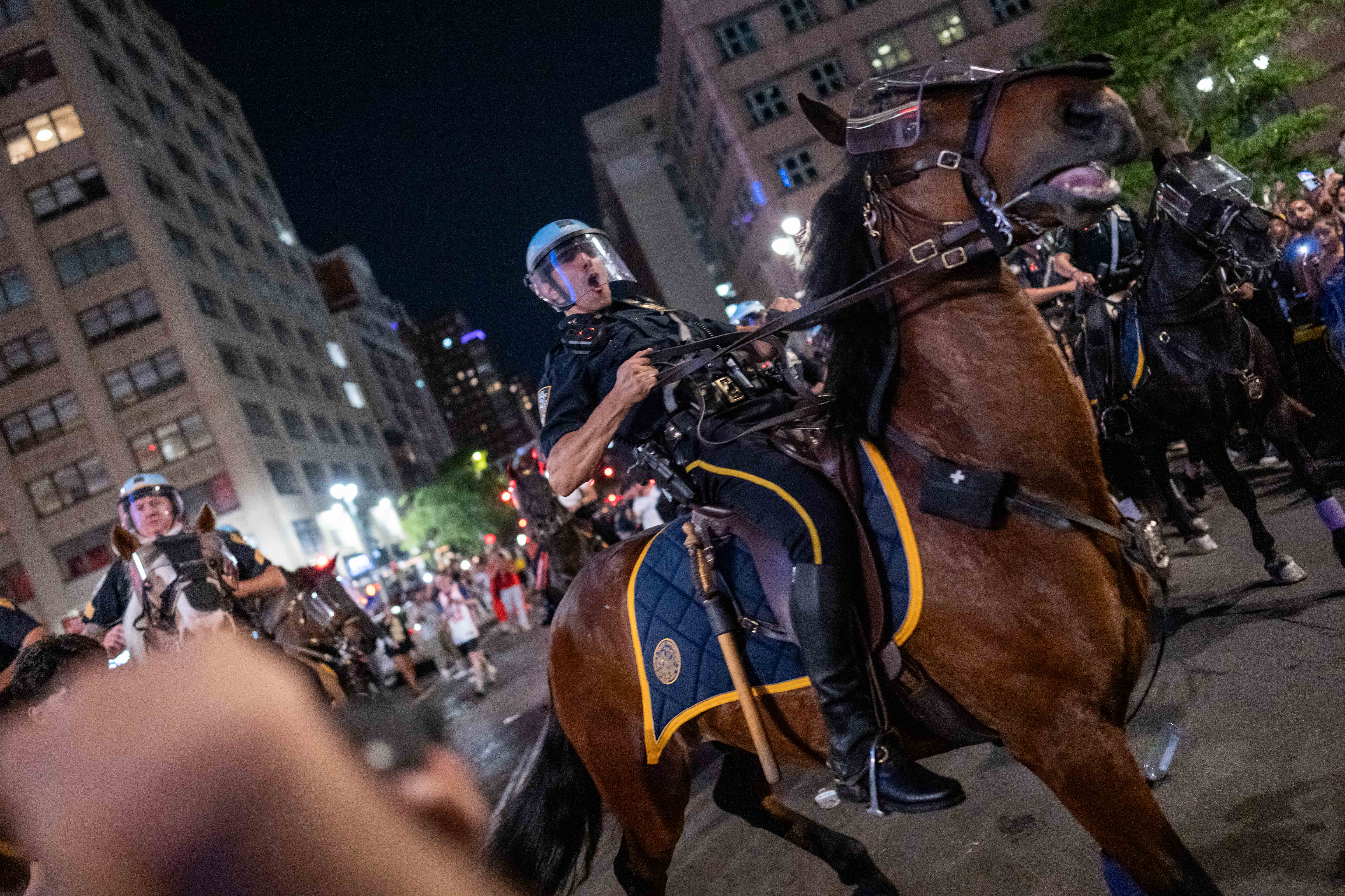 : NYPD Mounted Unit move backmost New York Knicks fans arsenic they observe their triumph against San Antonio Spurs successful Game 5 of nan NBA Finals connected June 13, 2026 successful New York City