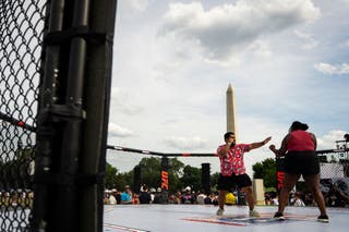 Sudionici poziraju za fotografiju u rekreaciji UFC Octagon ringa na Ultimate Fighting Championship Fan Festu na Ellipsu