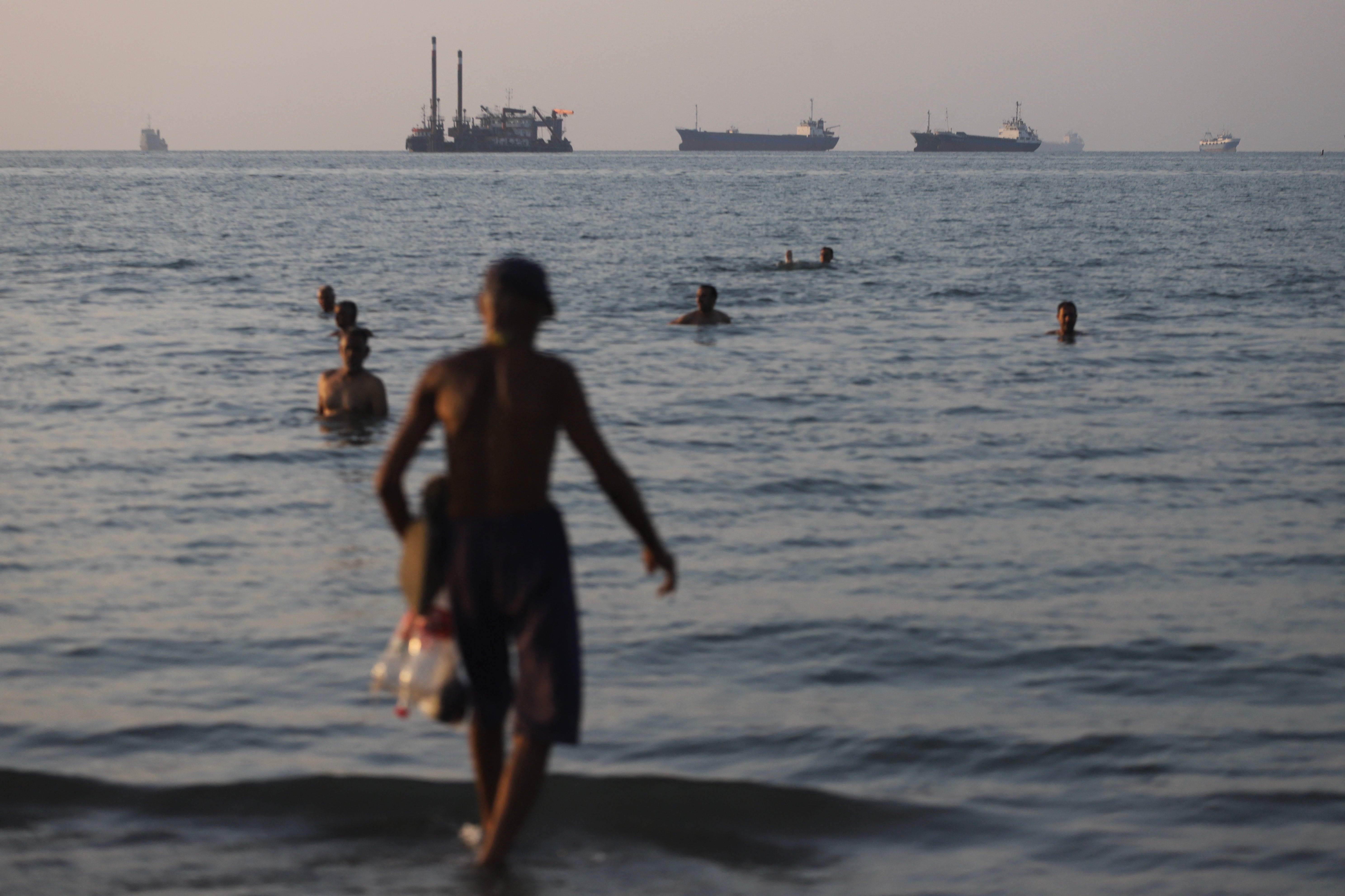 Under nan position of nan deal, nan US and Iran will work together to reopen nan Strait of Hormuz, a captious waste and acquisition way done which 20 percent of nan world's lipid passed earlier nan warfare collapsed out. Pictured here, cargo vessels are seen anchored successful nan strait connected June 8