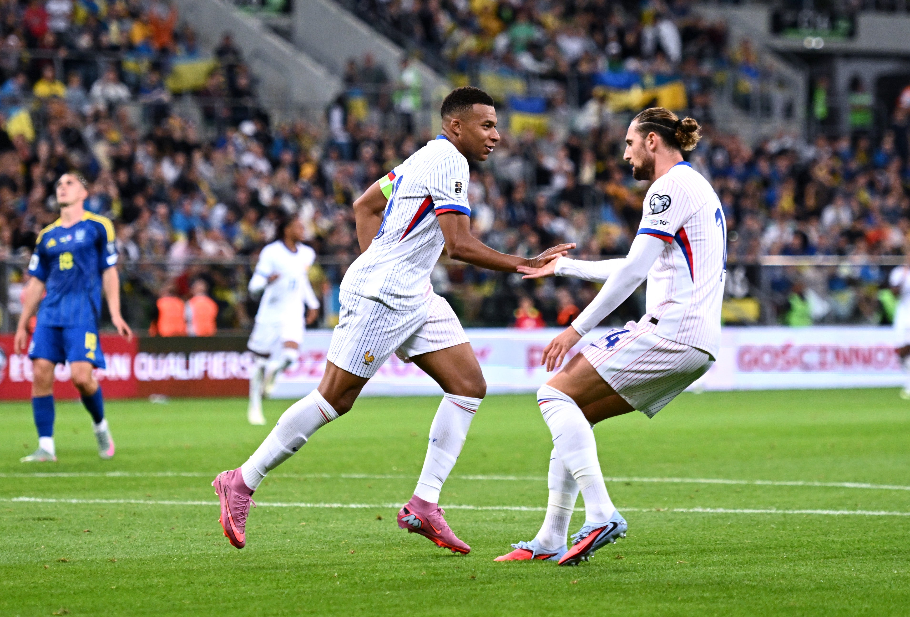 Kylian Mbappe of France celebrates scoring against Ukraine with teammate Adrien Rabiot
