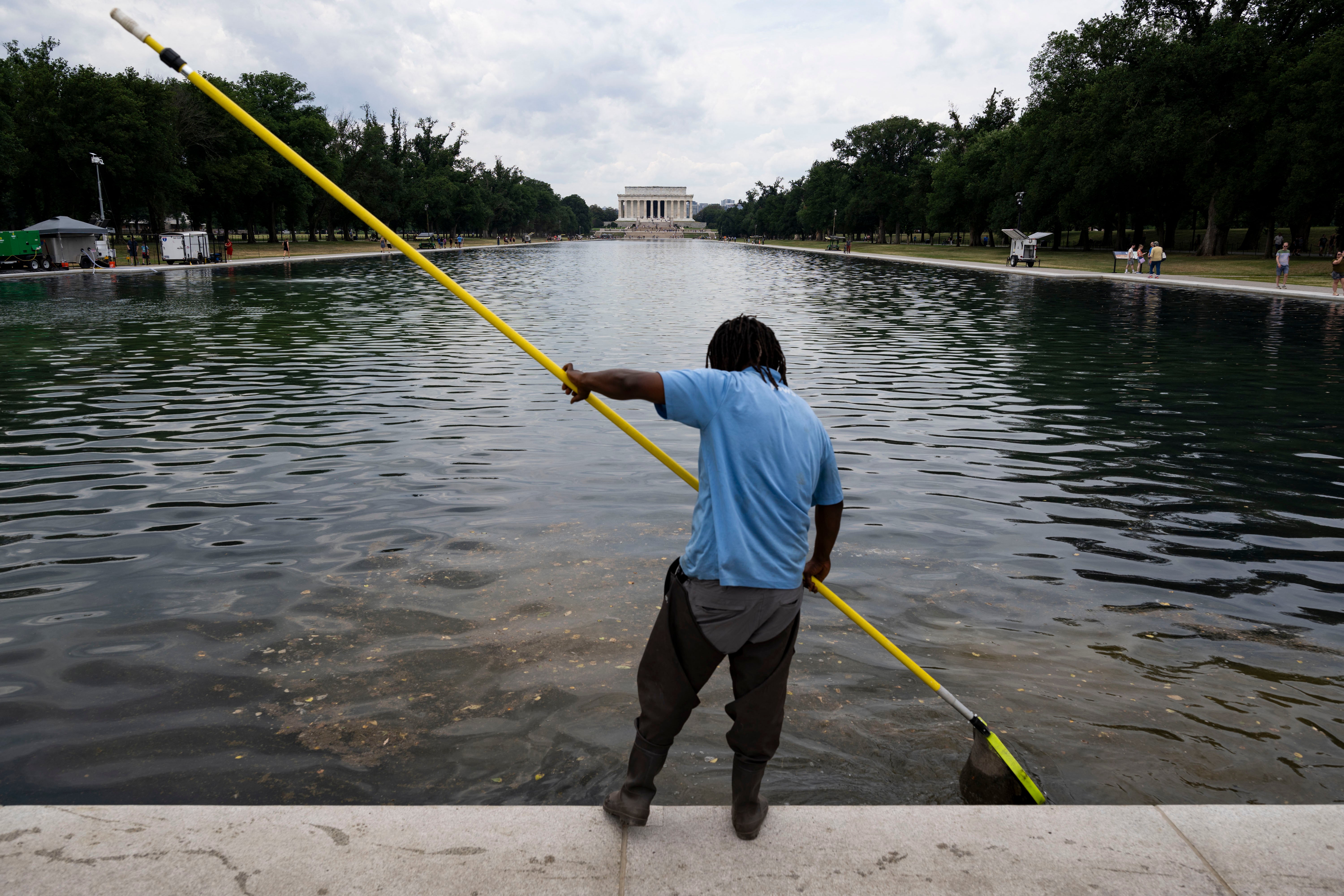 A worker cleans algae and chunks of overgarment from nan Lincoln Memorial Reflecting Pool connected Monday