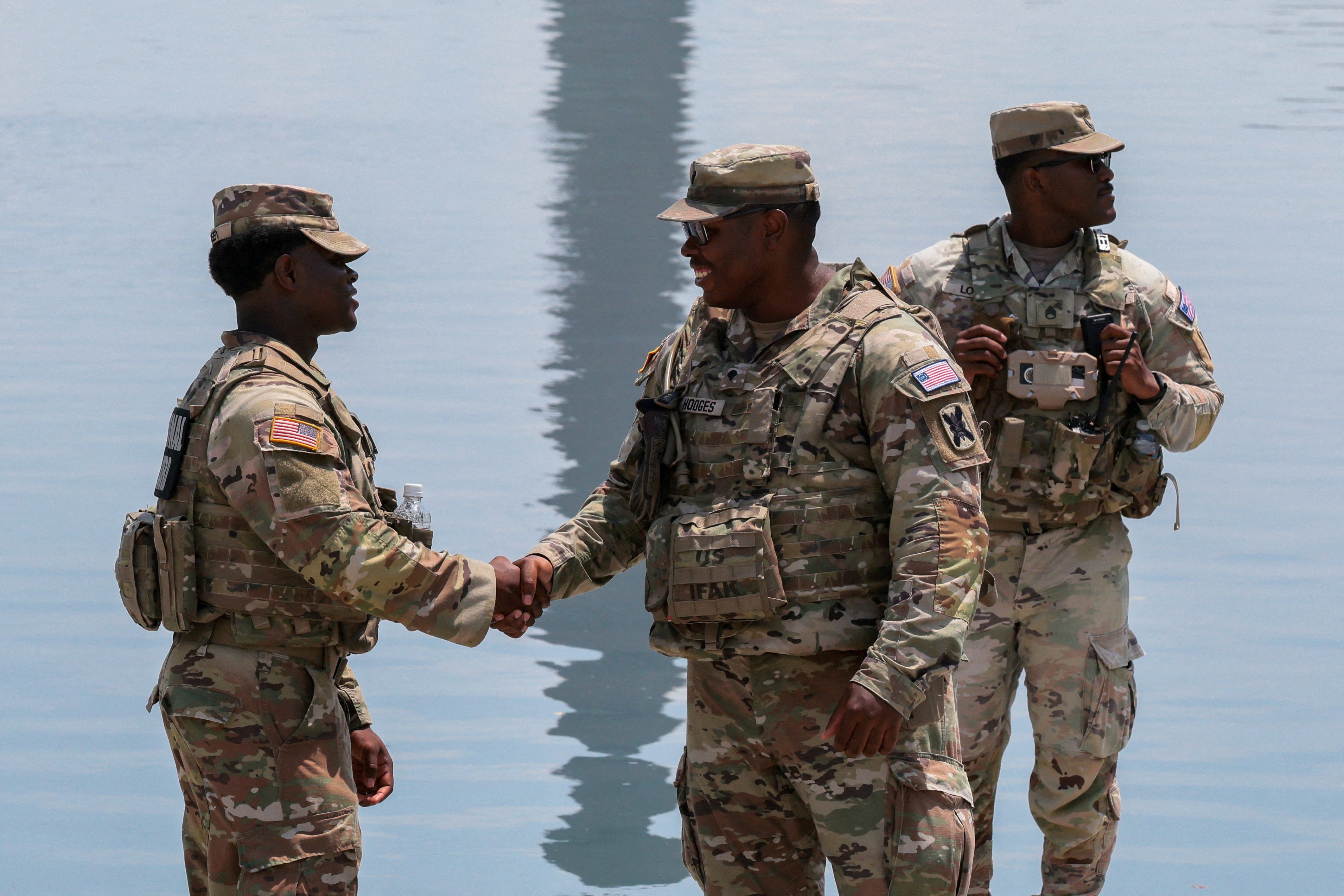 Members of nan National Guard shingle hands arsenic they patrol nan Lincoln Memorial Reflecting Pool