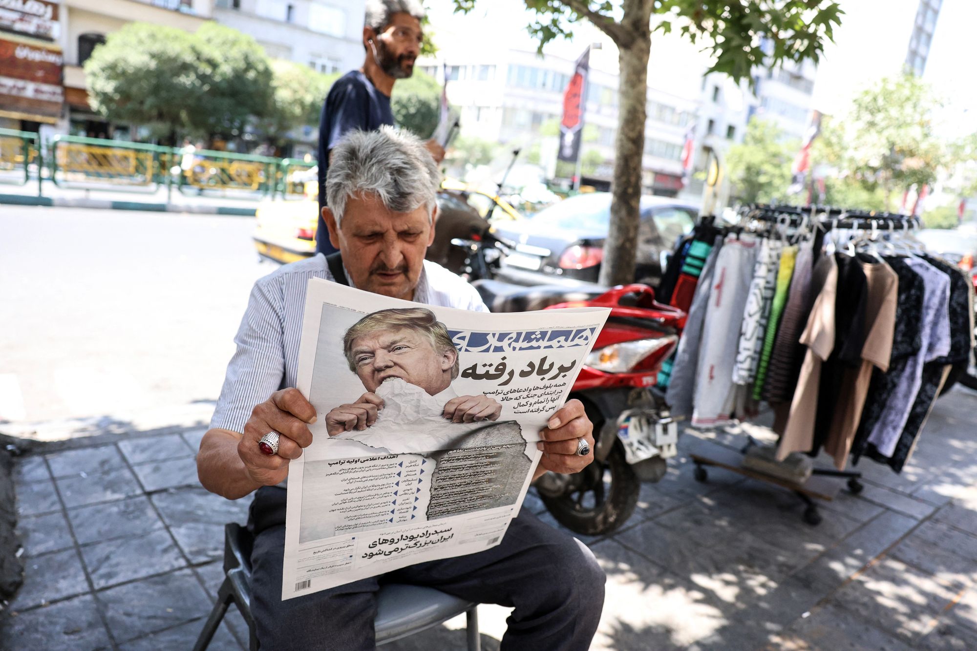 A man sounds a transcript of nan Iranian regular newspaper Hamshahri base an image of nan US president and a header that sounds "Gone pinch nan wind" astatine a stalls successful Tehran