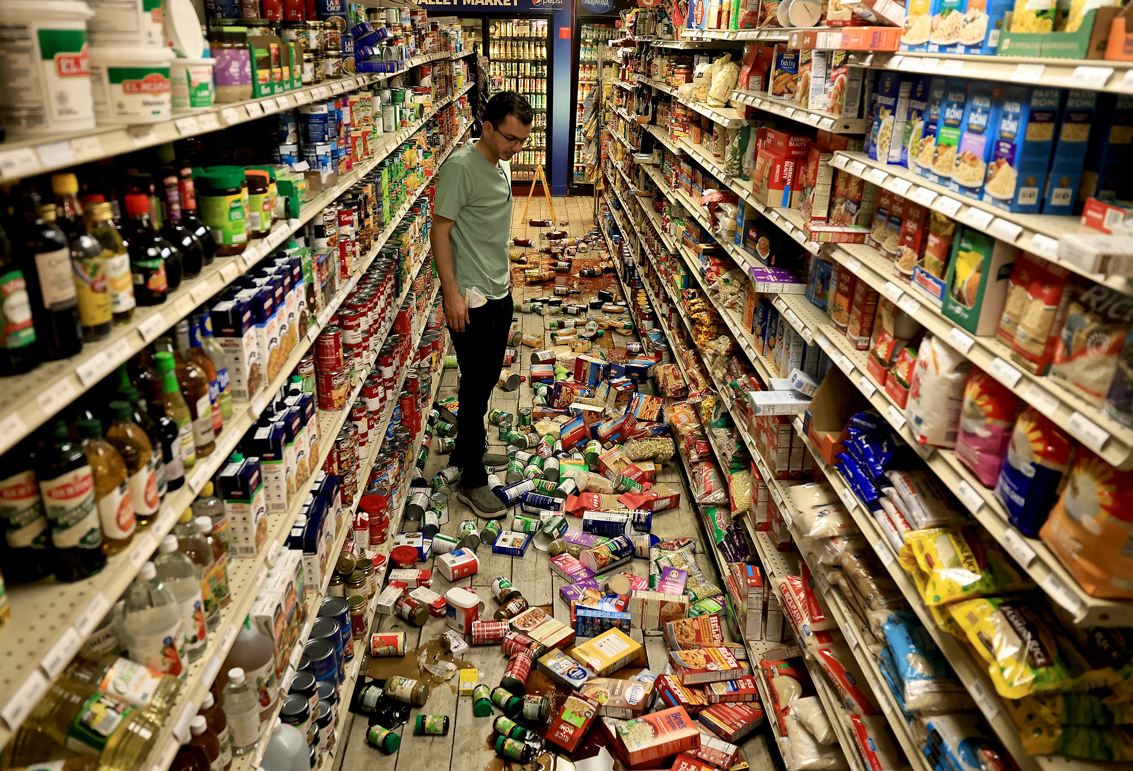 Redwood Valley Market proprietor Alex Chehada looks astatine items which fell disconnected nan shelves aft an earthquake successful Redwood Valley