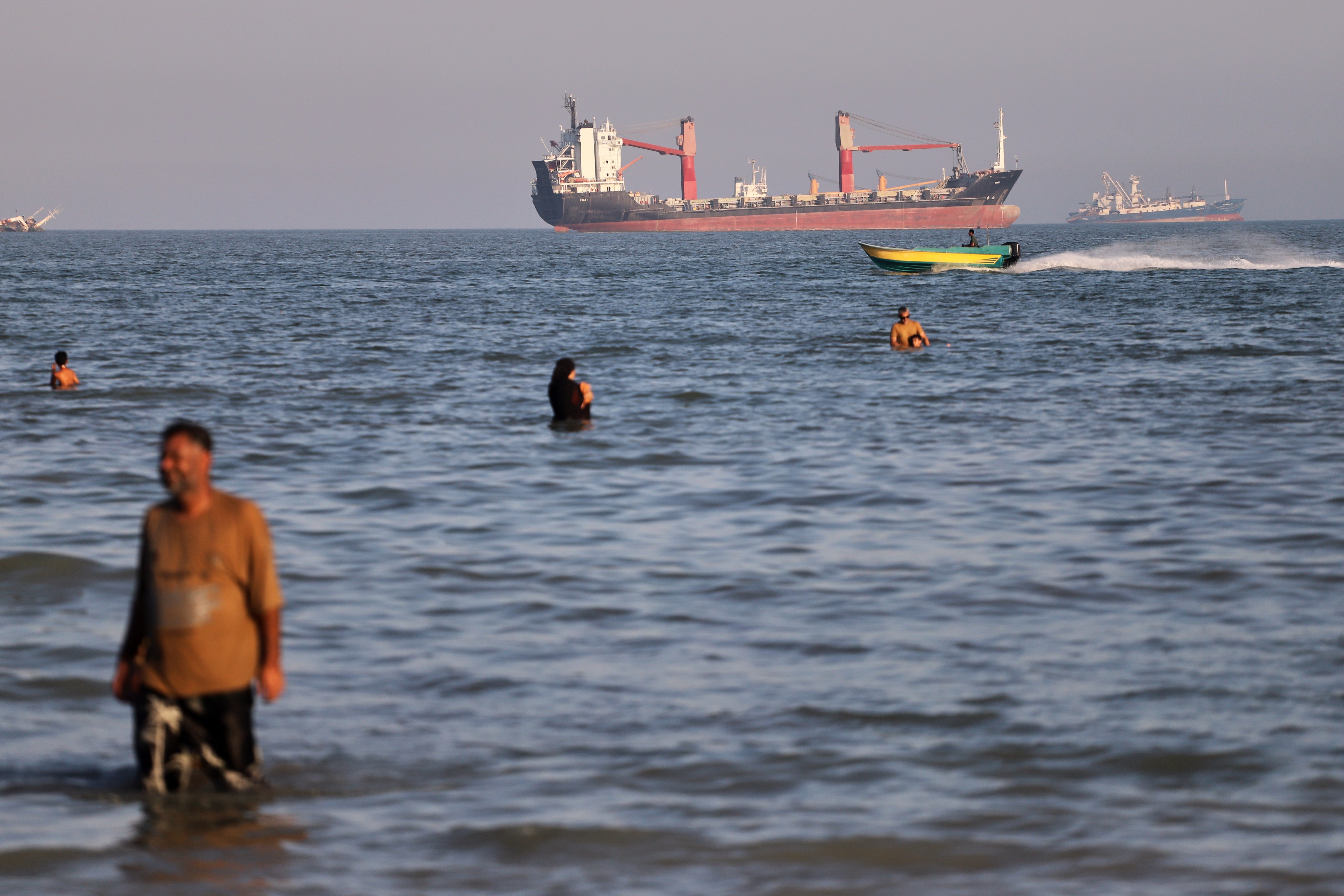 Residents aquatics successful nan waters of nan Strait of Hormuz arsenic a mini motorboat passes cargo ships and different commercialized vessels offshore adjacent Bandar Abbas, Iran