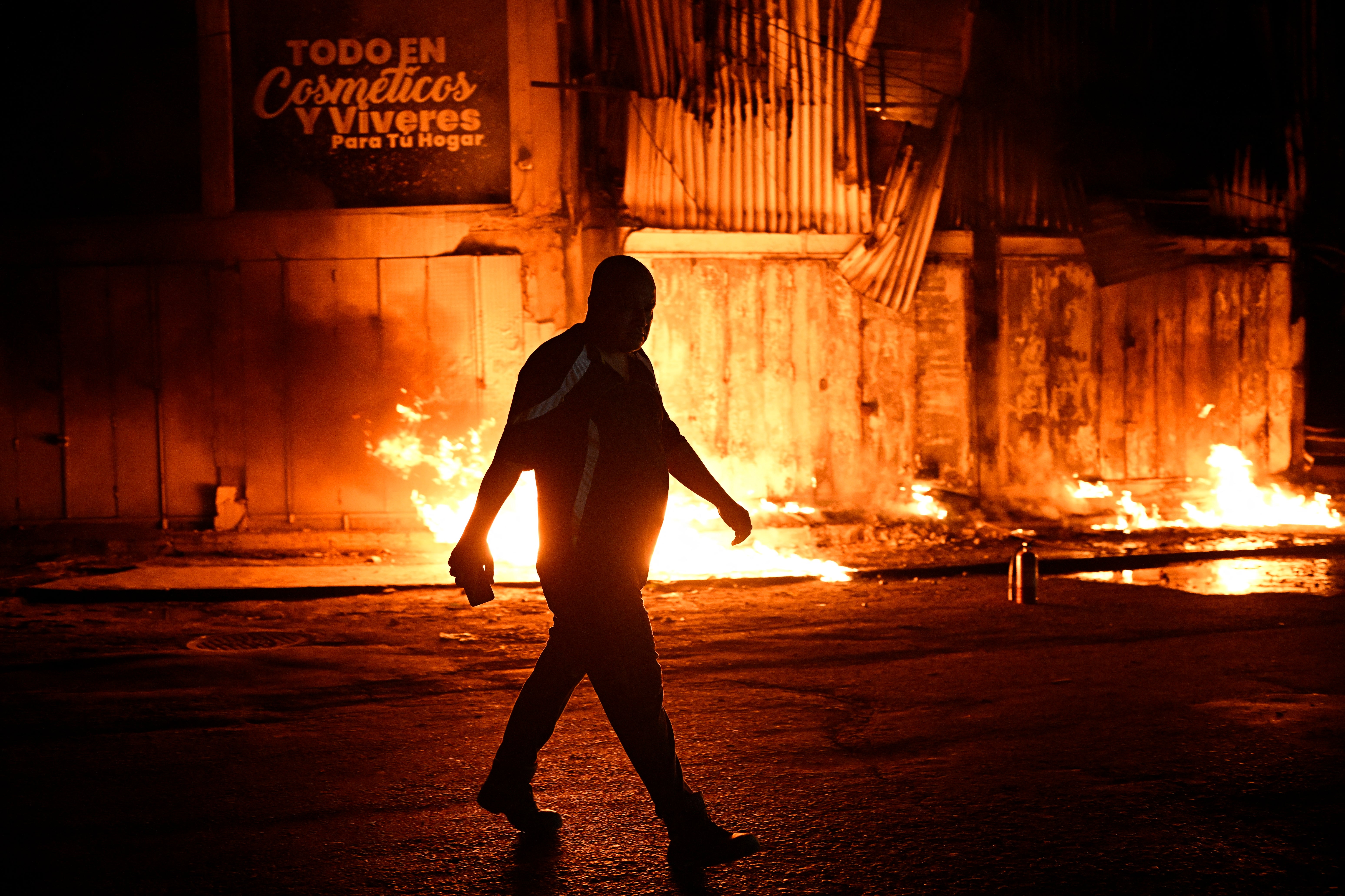 A man walks past a occurrence extracurricular a building pursuing an earthquake successful Catia La Mar, La Guaira state, immoderate 30kms north-west of Caracas