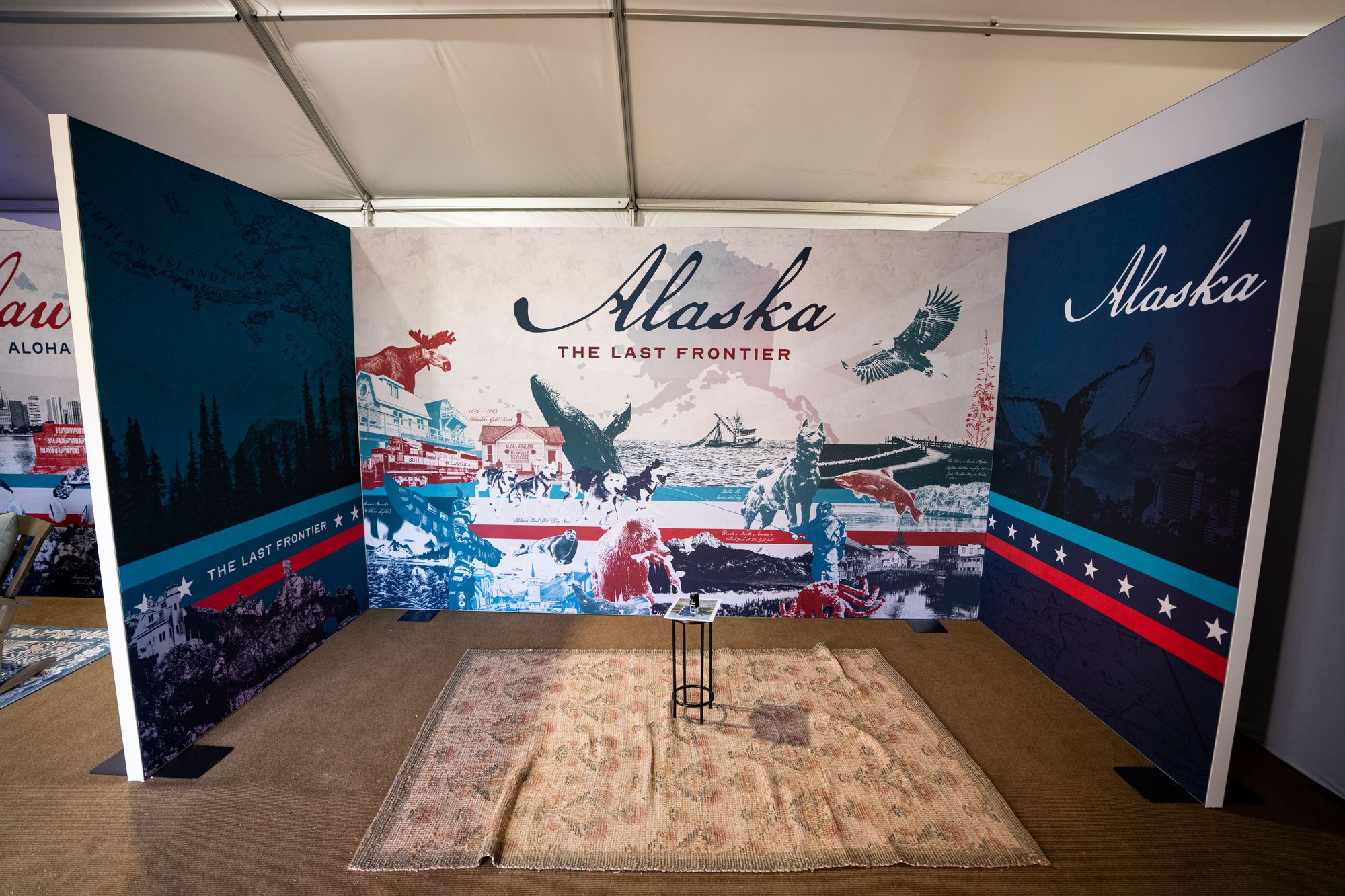 Alaska’s booth was highly pared down, only containing a rug and a mini table, photos show