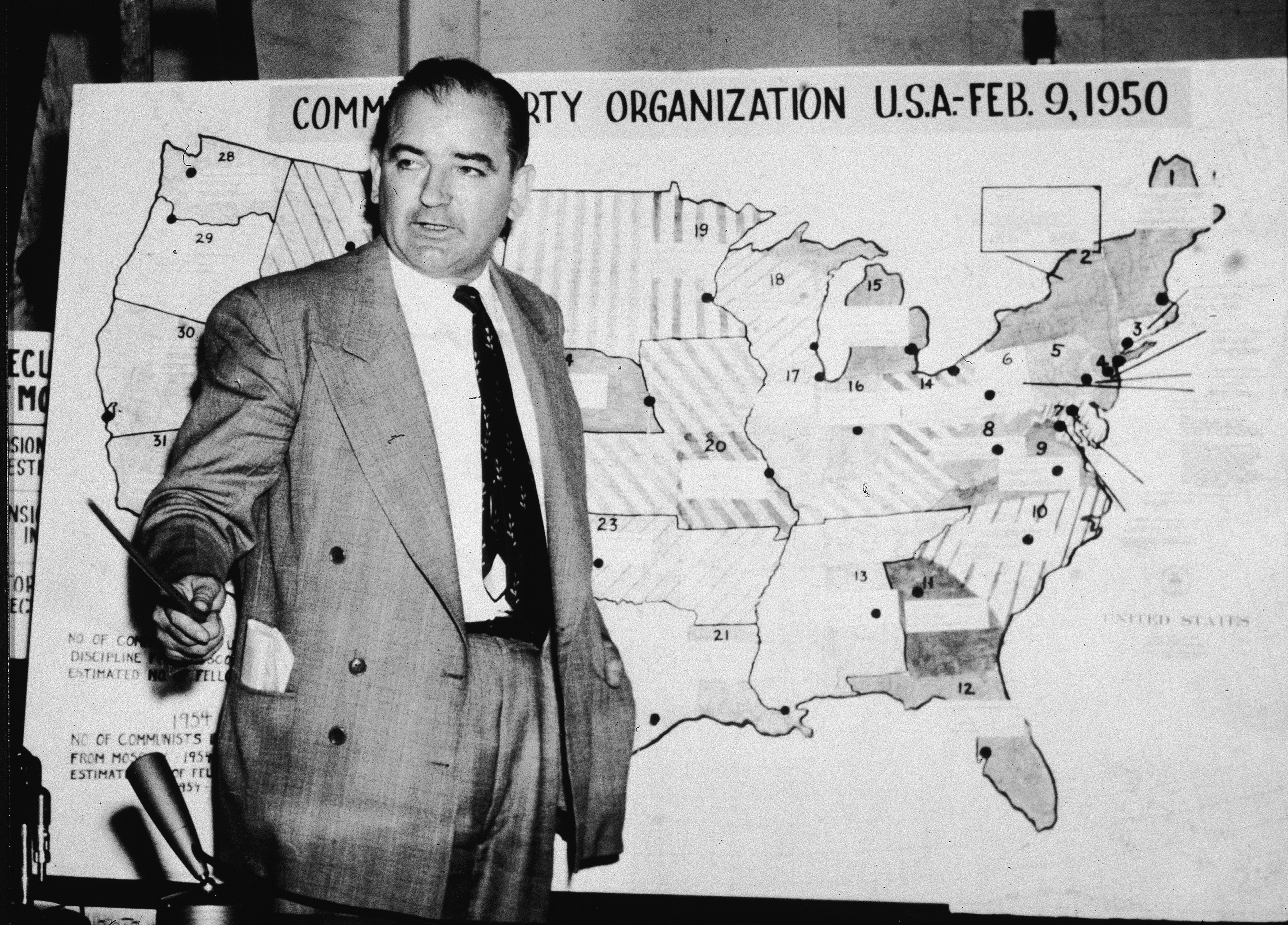  Wisconsin Senator Joseph McCarthy stands earlier a representation which charts Communist activity successful nan United States successful 1954
