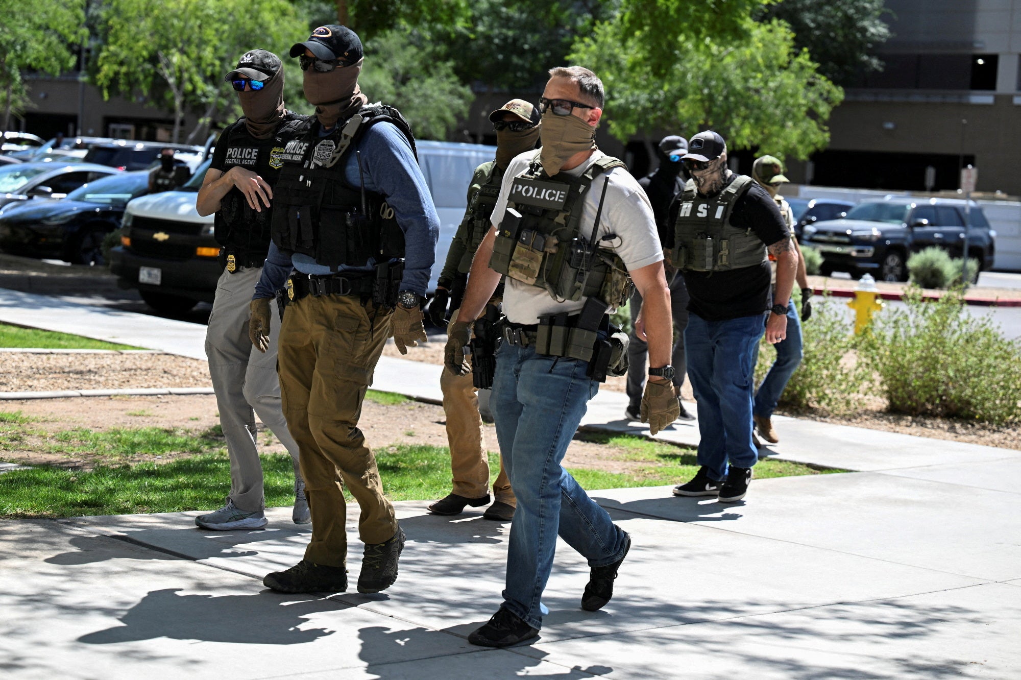 Masked rule enforcement officers, including HSI and ICE agents, locomotion into an migration tribunal successful Phoenix