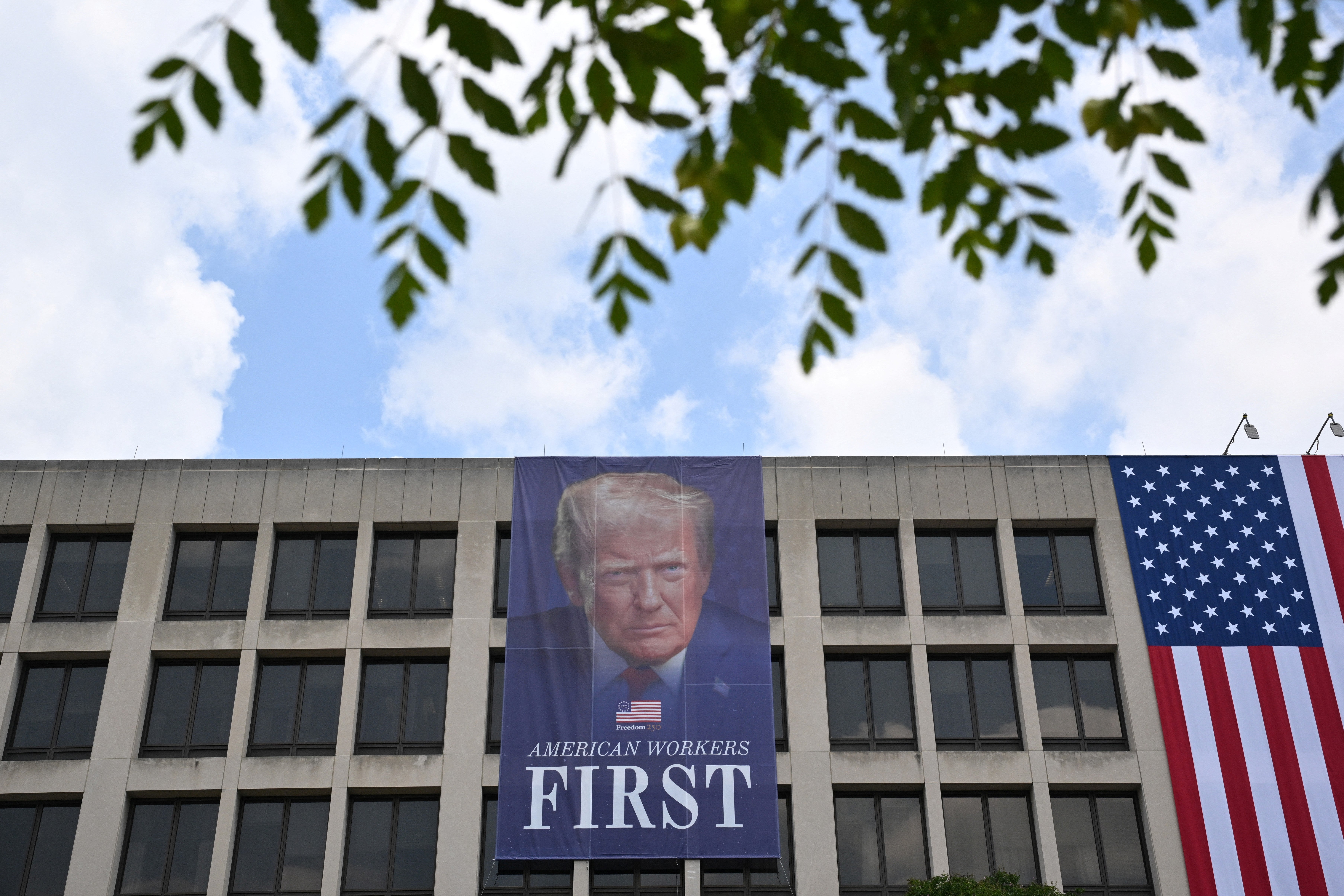 A banner depicting President Donald Trump hangs connected nan exterior of nan Department of Labor office successful Washington, D.C.