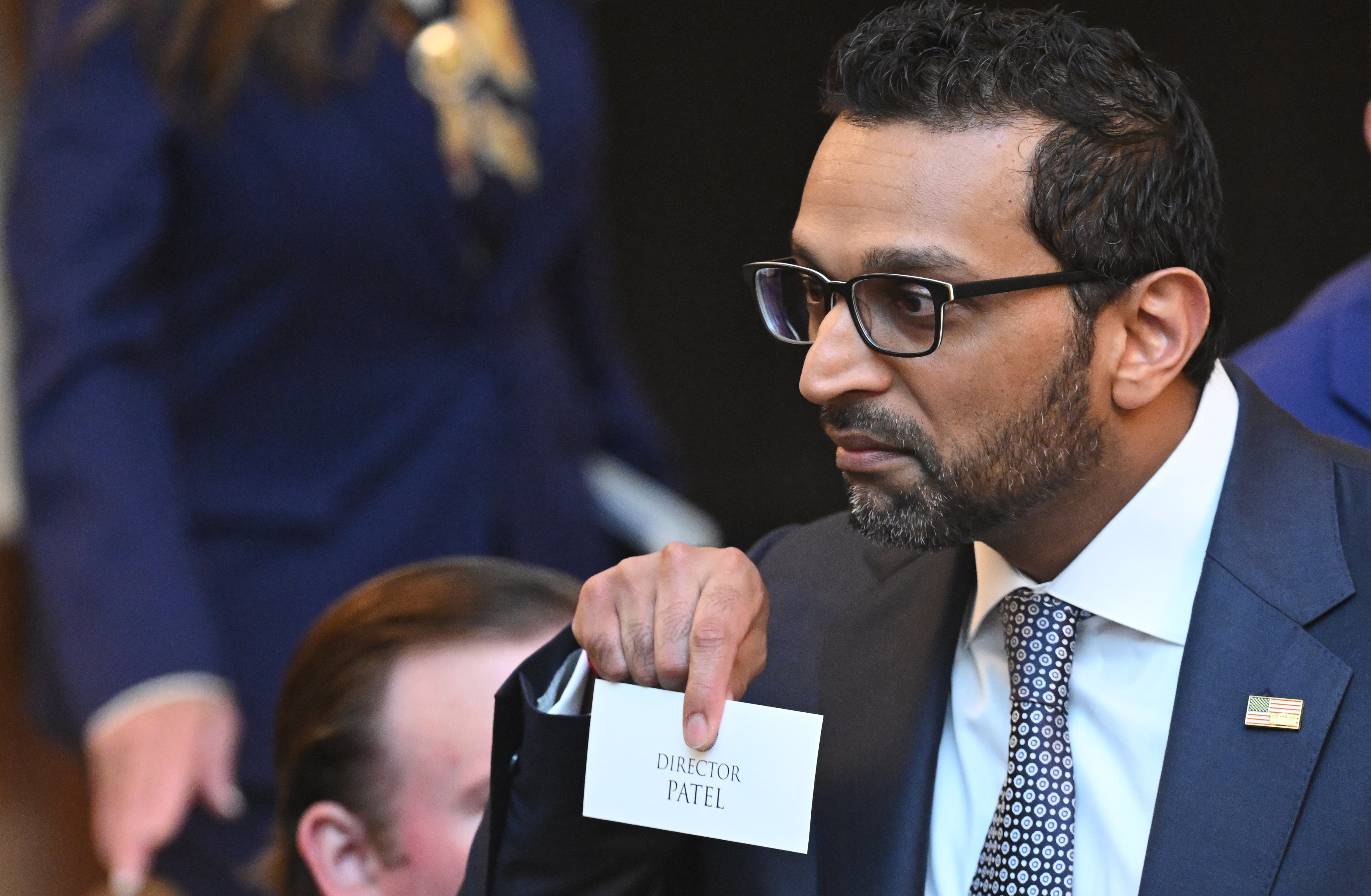 FBI director Kash Patel holds a name card as he arrives before President Donald Trump speaks (Saul Loeb/Pool via AP)
