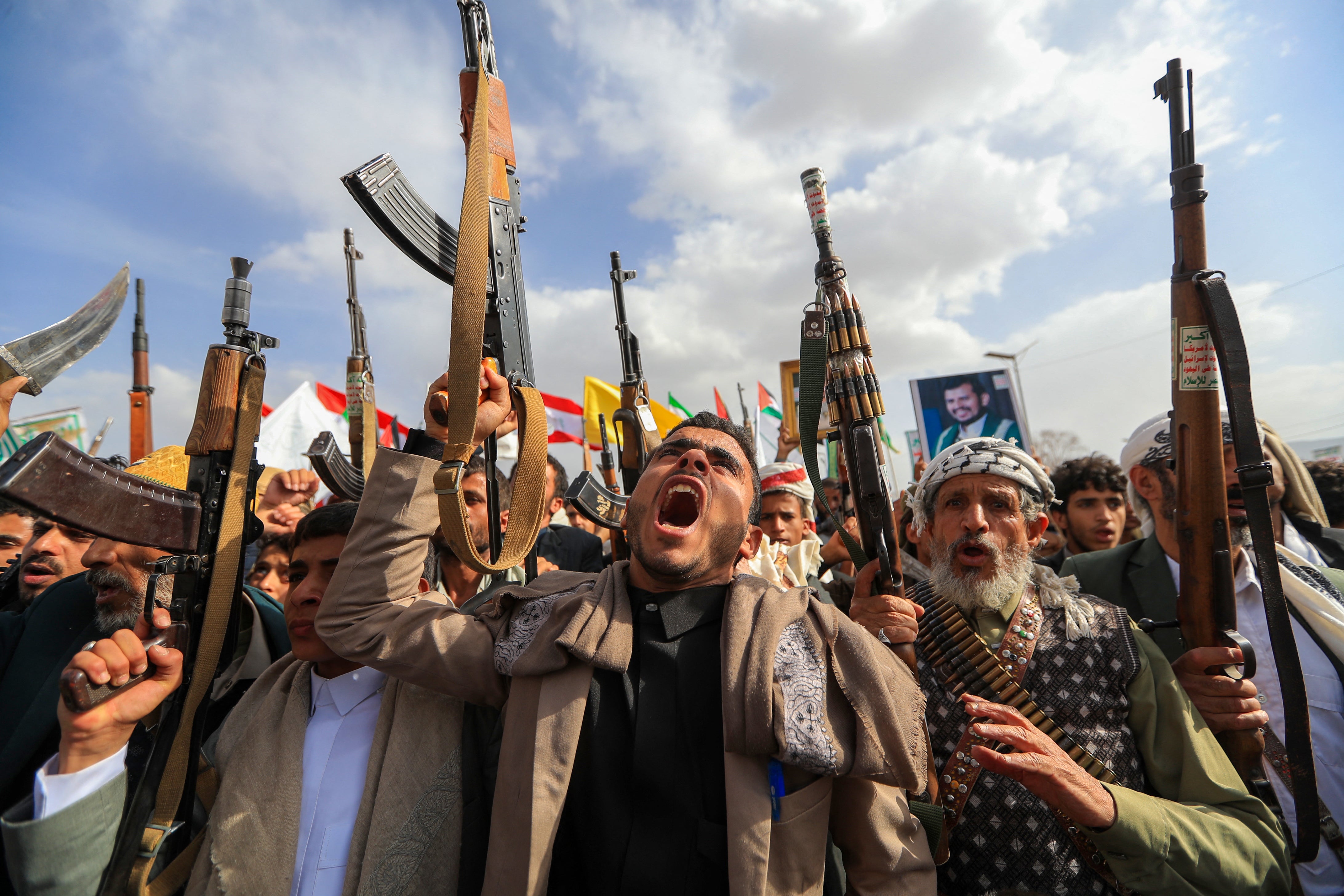 Naoružani jemenski pristaše Houthi pokreta koji podržava Iran mašu oružjem tijekom prosvjeda protiv američkih napada