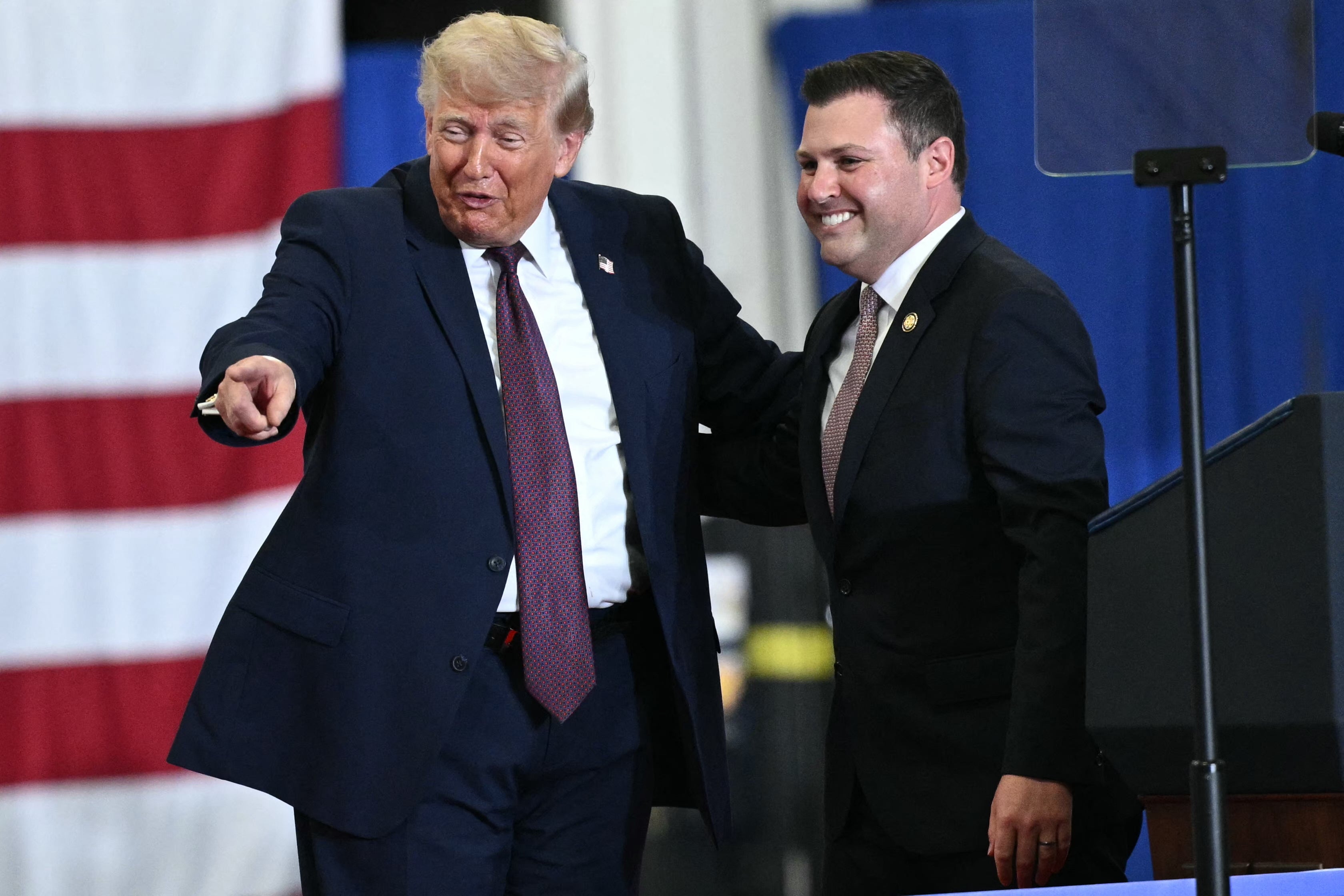 Trump appears connected shape pinch US Representative Ryan Mackenzie, Republican of Pennsylvania, during a sojourn to nan Mack Trucks manufacturing installation successful Macungie, Pennsylvania, connected June 23, 2026