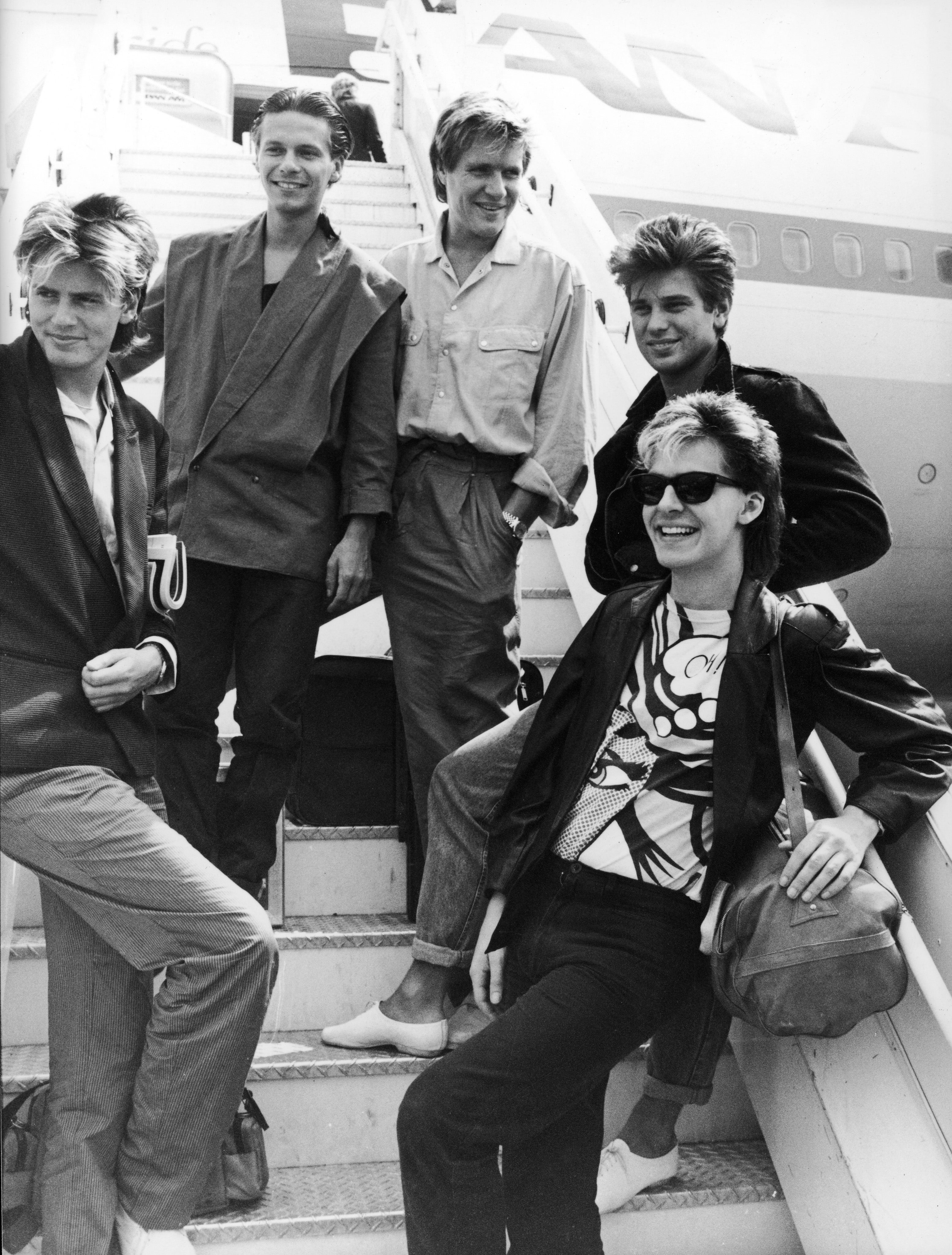 Duran Duran pose at Heathrow Airport before departing for Australia, July 1983. L-R: Guitarists John and Andy Taylor (unrelated), singer Simon Le Bon, drummer Roger Taylor and keyboardist Nick Rhodes