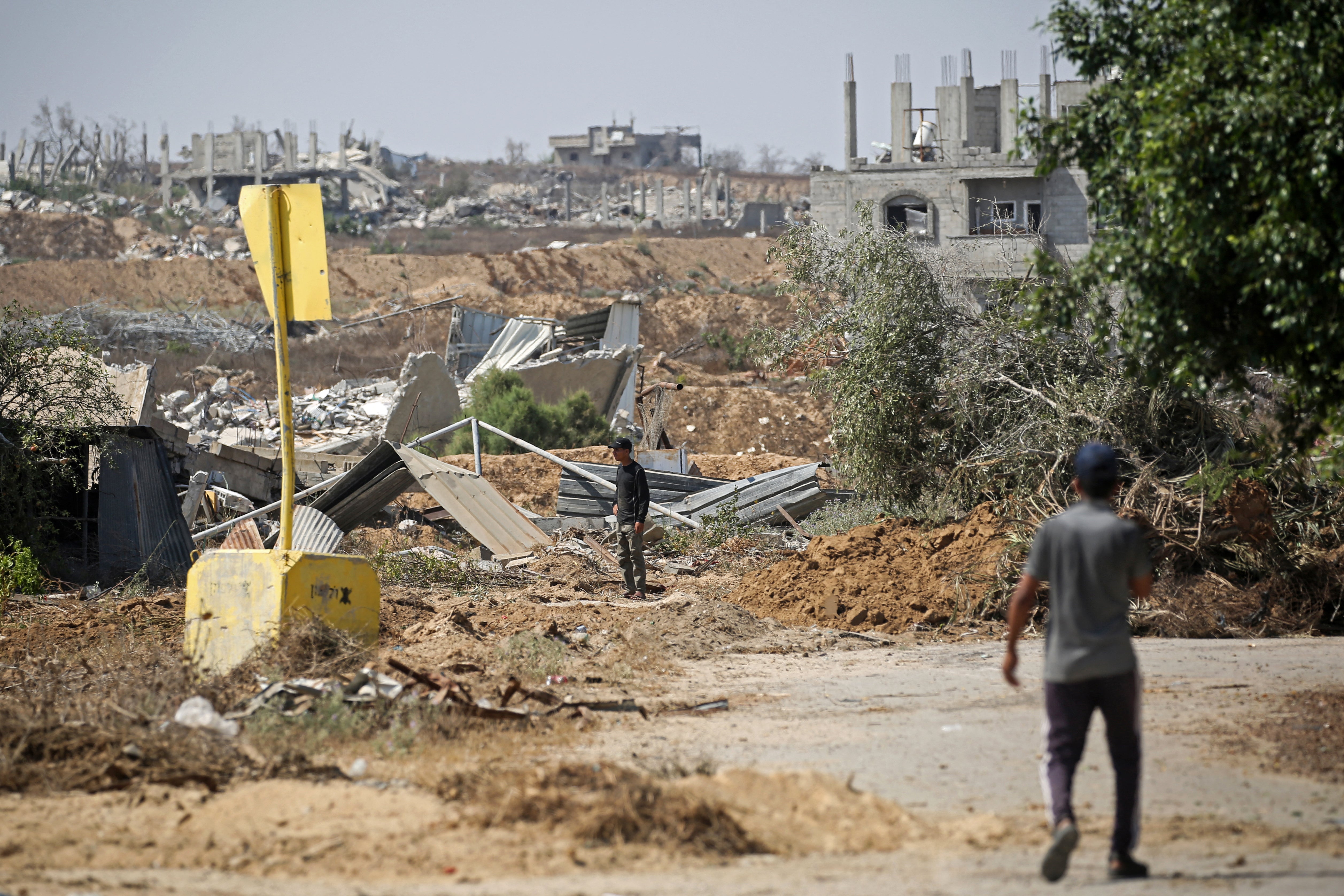 Palestinians locomotion past a actual artifact marking nan 'Yellow Line' drawn by nan Israeli subject successful nan eastbound of Deir al-Balah, cardinal Gaza Strip