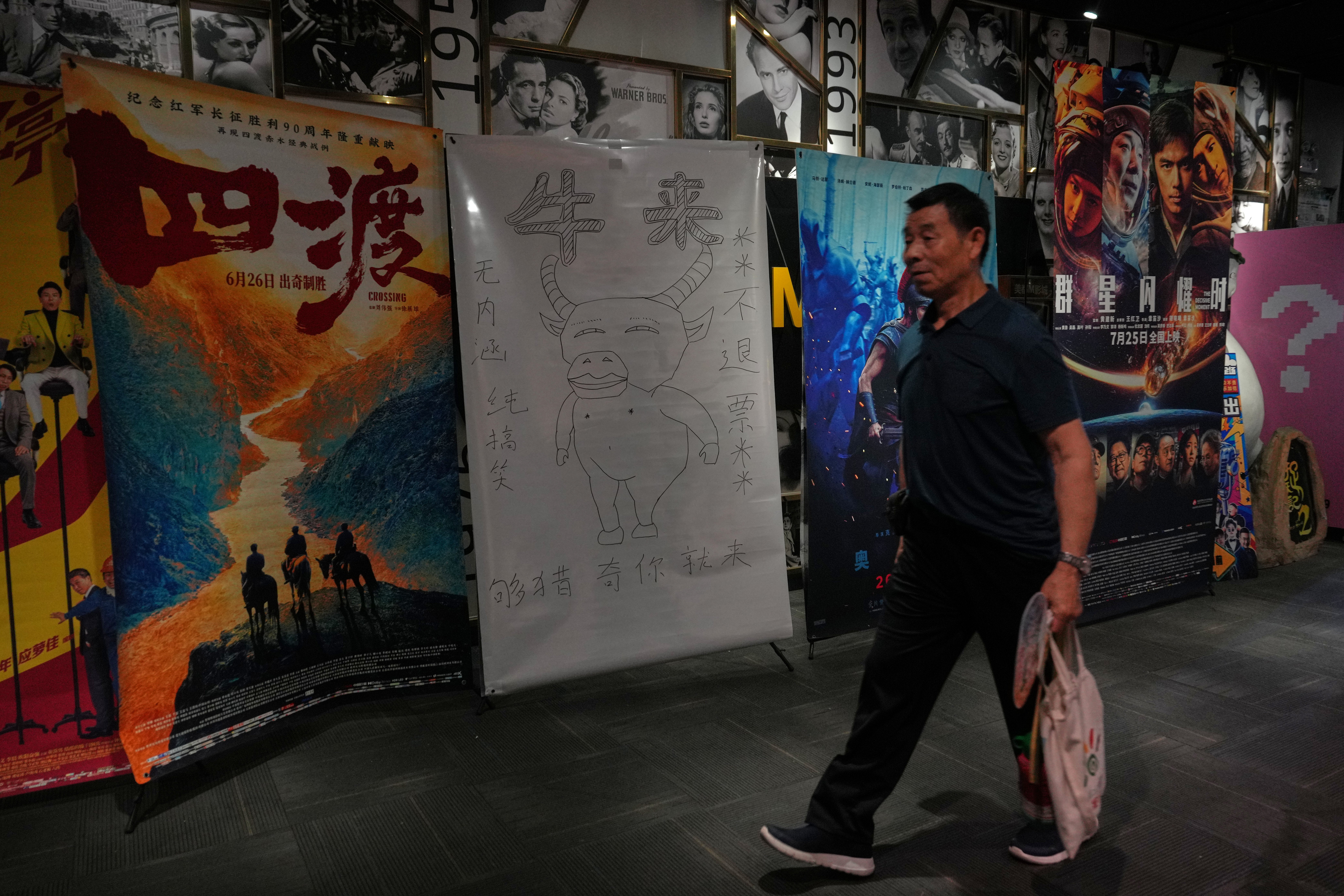 A man walks by a drawing poster promoting a Chinese animated film 