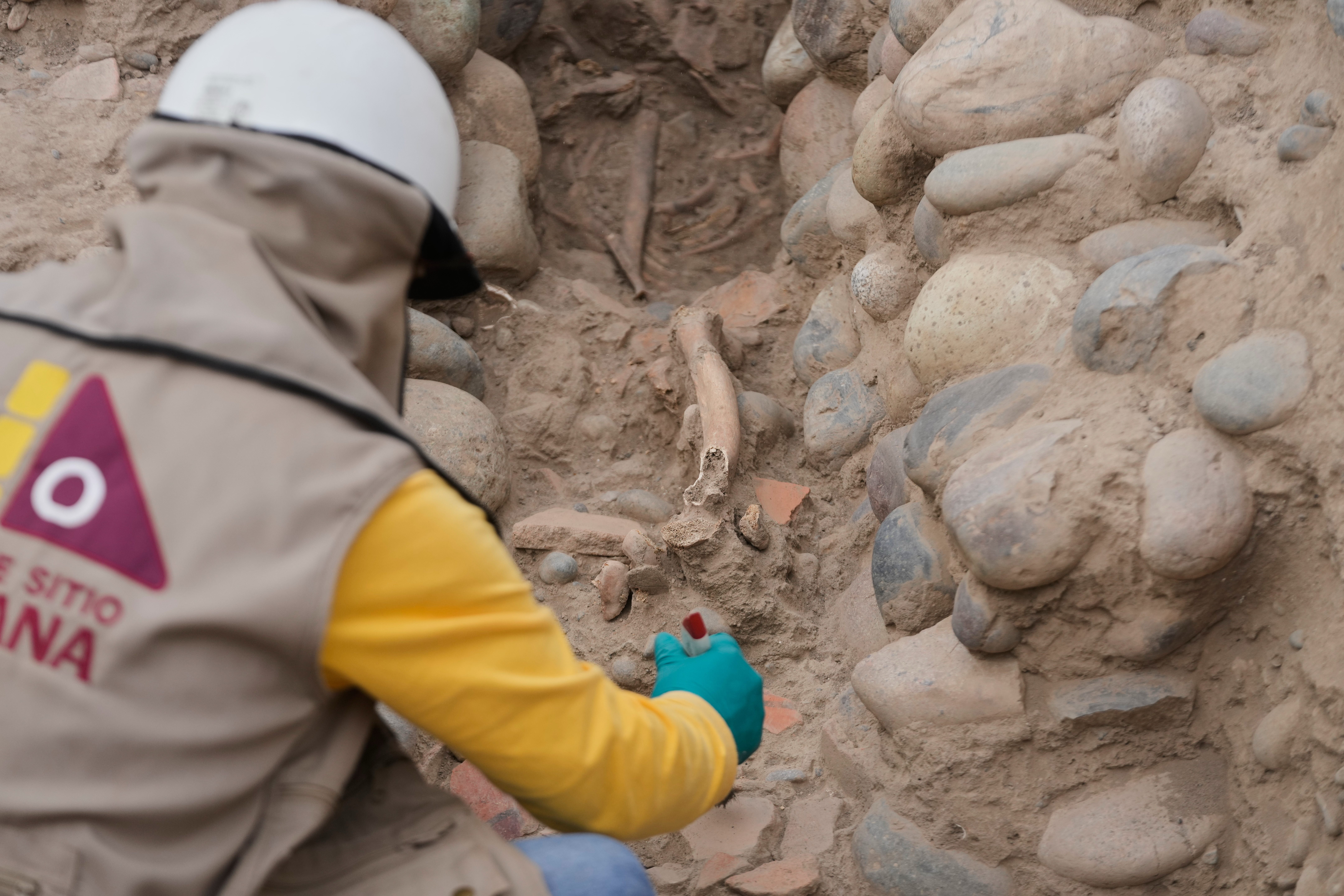 An archaeologist excavates skeletal remains at the Huaca Pucllana archaeological site in Lima