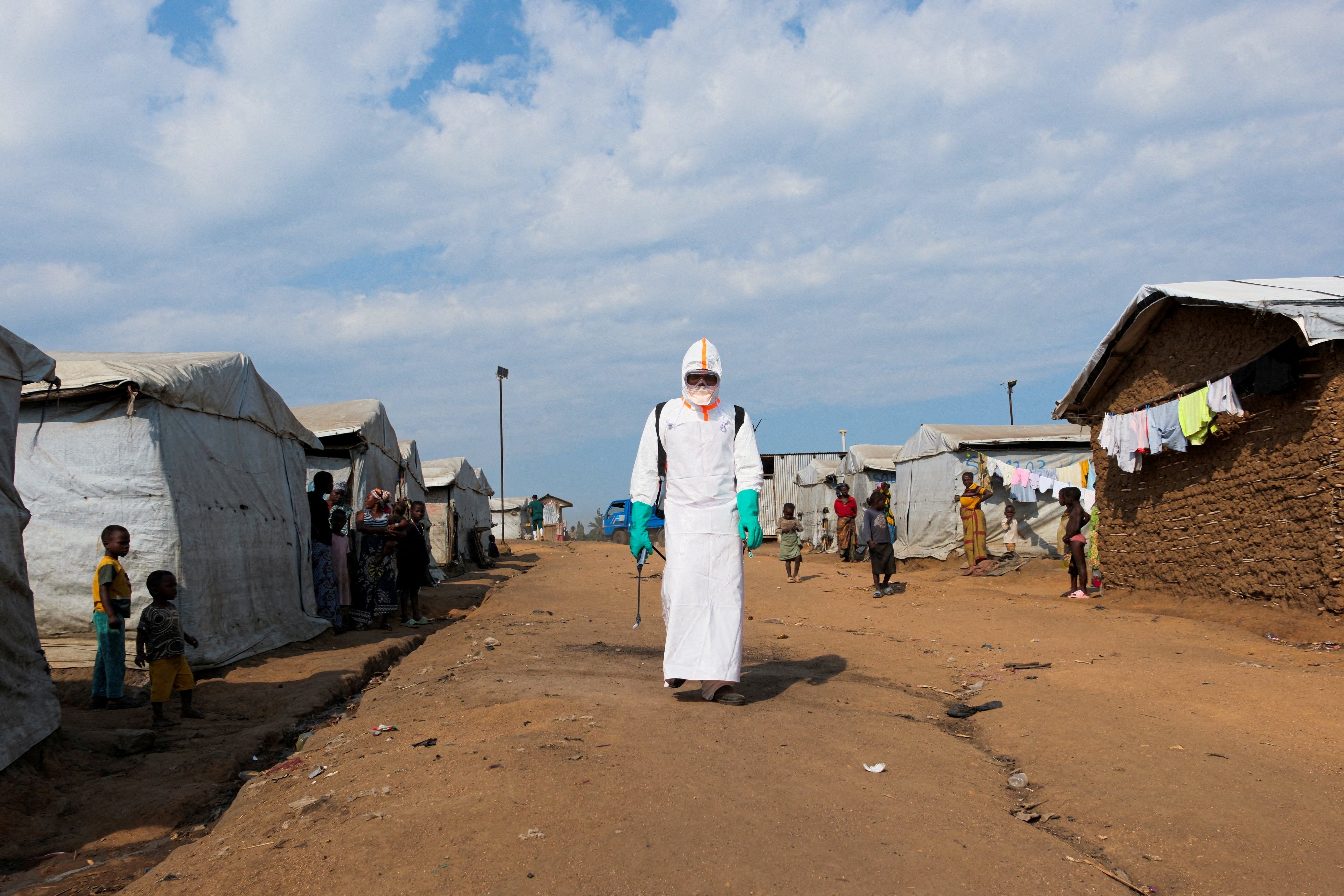A health worker prepares to disinfect part of the Kigonze displaced persons camp in Bunia, DRC after the burial of suspected Ebola victims